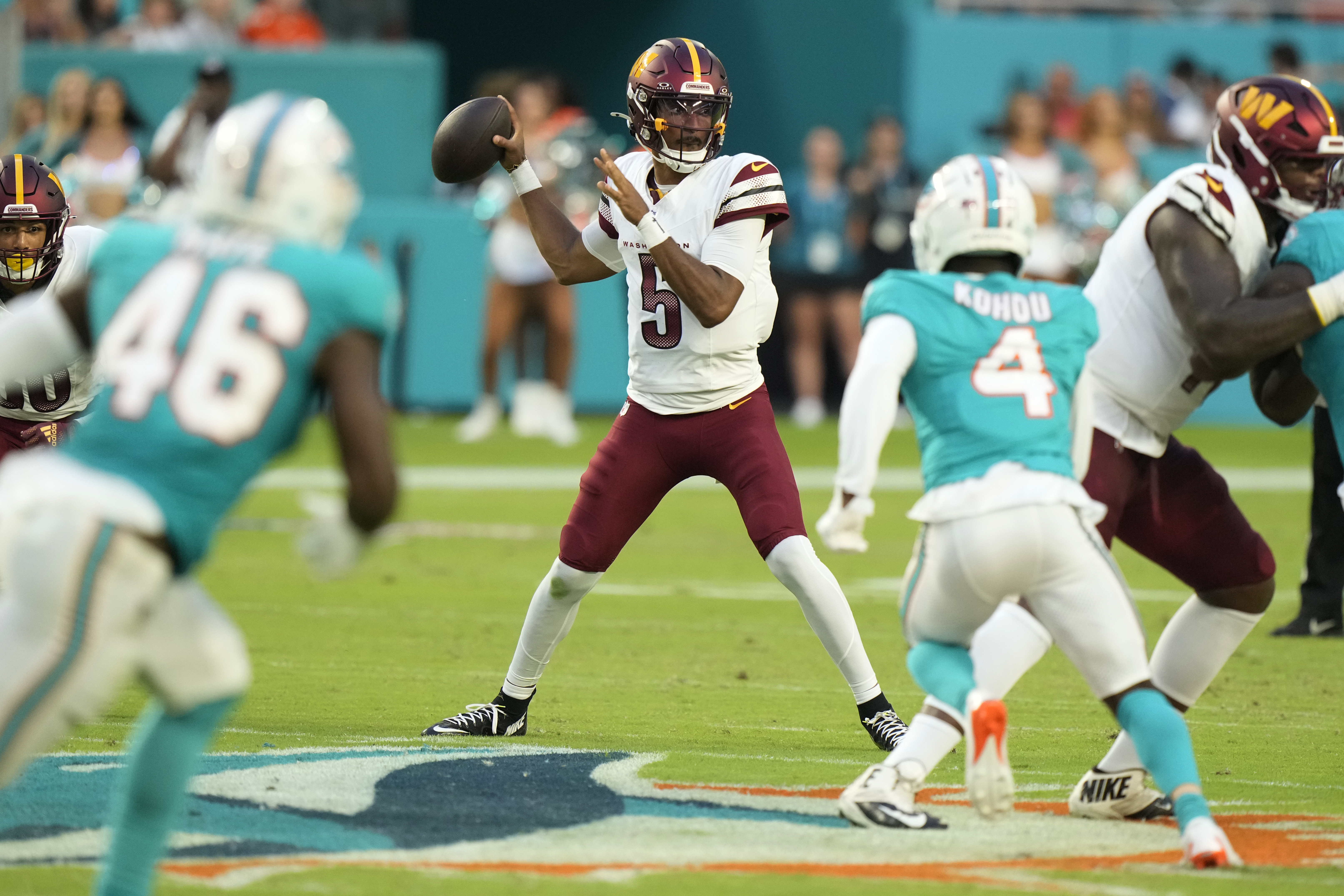 Washington Commanders quarterback Jayden Daniels (5) stands back to pass during the first half of a preseason NFL football game against the Miami Dolphins, Saturday, Aug. 17, 2024, in Miami Gardens, Fla. 