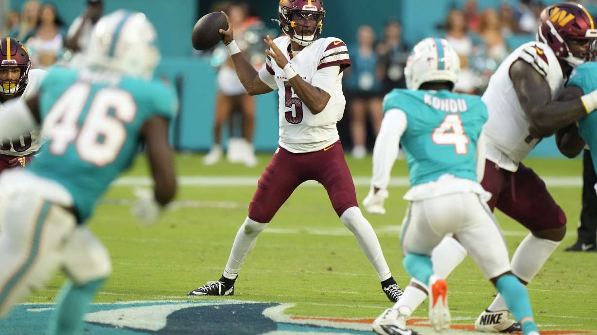 Washington Commanders quarterback Jayden Daniels (5) stands back to pass during the first half of a preseason NFL football game against the Miami Dolphins, Saturday, Aug. 17, 2024, in Miami Gardens, Fla.