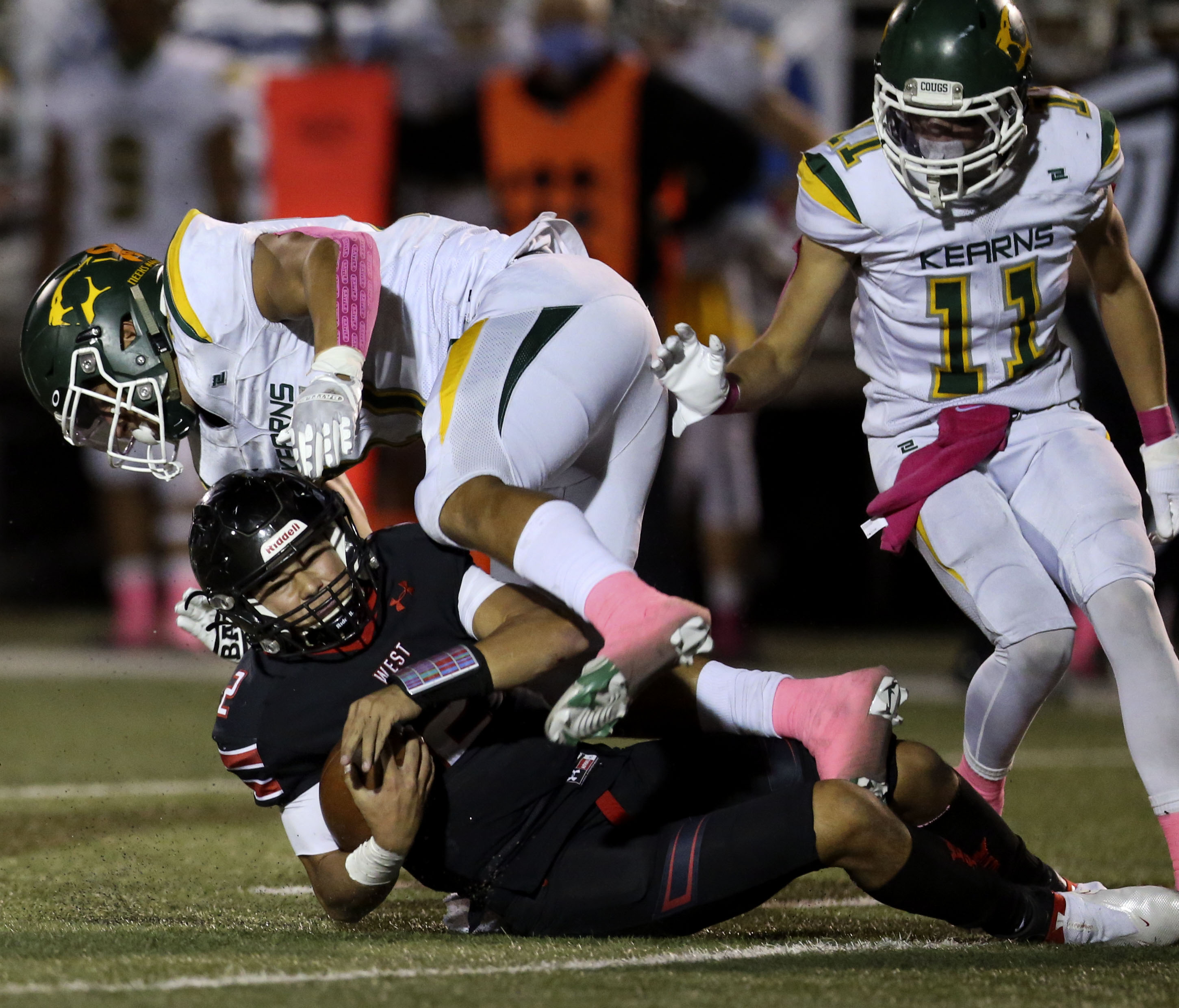 West High quarterback Karson Lopati slides into Kearns linebacker Jack Kelly (17) at West High School in Salt Lake City on Friday, Oct. 9, 2020.