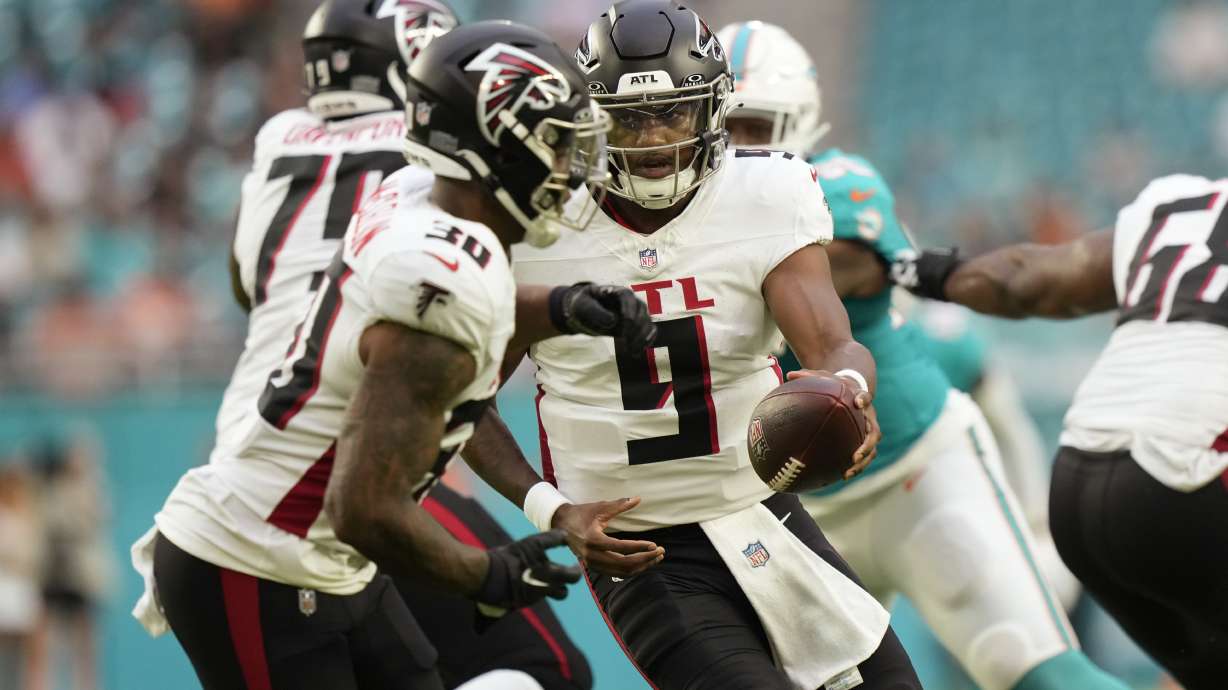 Atlanta Falcons quarterback Michael Penix Jr. (9) hands the ball to running back Jase McClellan (30) during the first half of a pre season NFL football game against the Miami Dolphins, Friday, Aug. 9, 2024, in Miami Gardens, Fla.