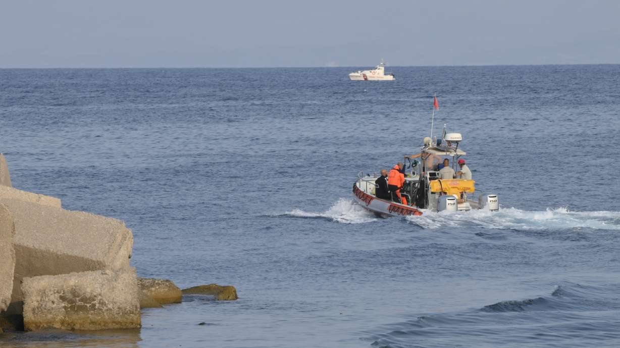 Divers sail toward the area where the UK flag vessel Bayesan was hit by a violent sudden storm and sunk early Monday, while at anchor off the Sicilian village of Porticello near Palermo, in southern Italy.
