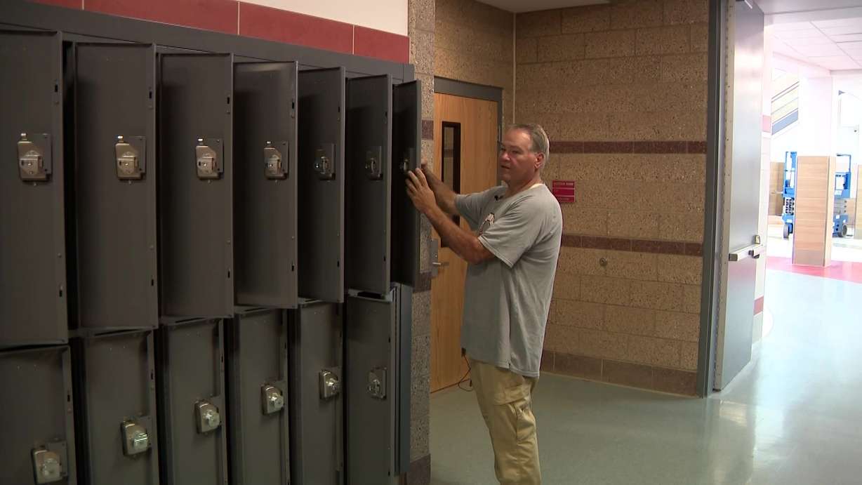 Kevan Sprague cleans one of thousands of lockers that need cleaning before the school year starts.