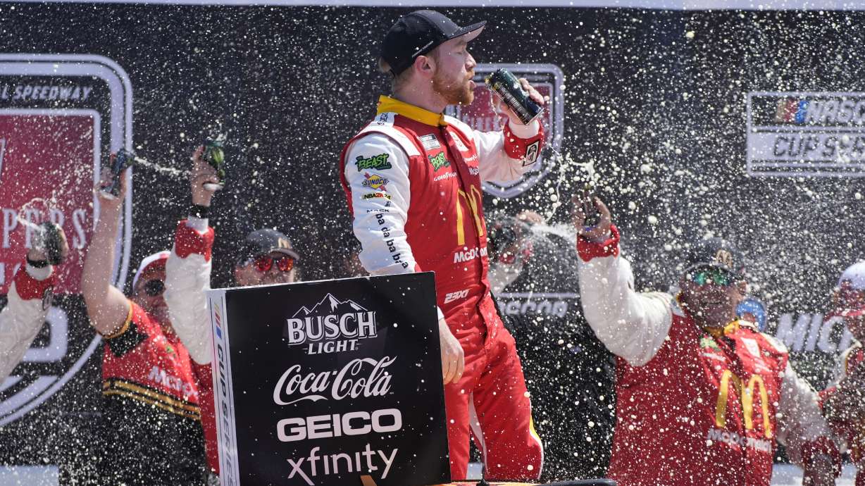 Tyler Reddick stands on his car after winning a NASCAR Cup Series auto race at Michigan International Speedway, Monday, Aug. 19, 2024, in Brooklyn, Mich.