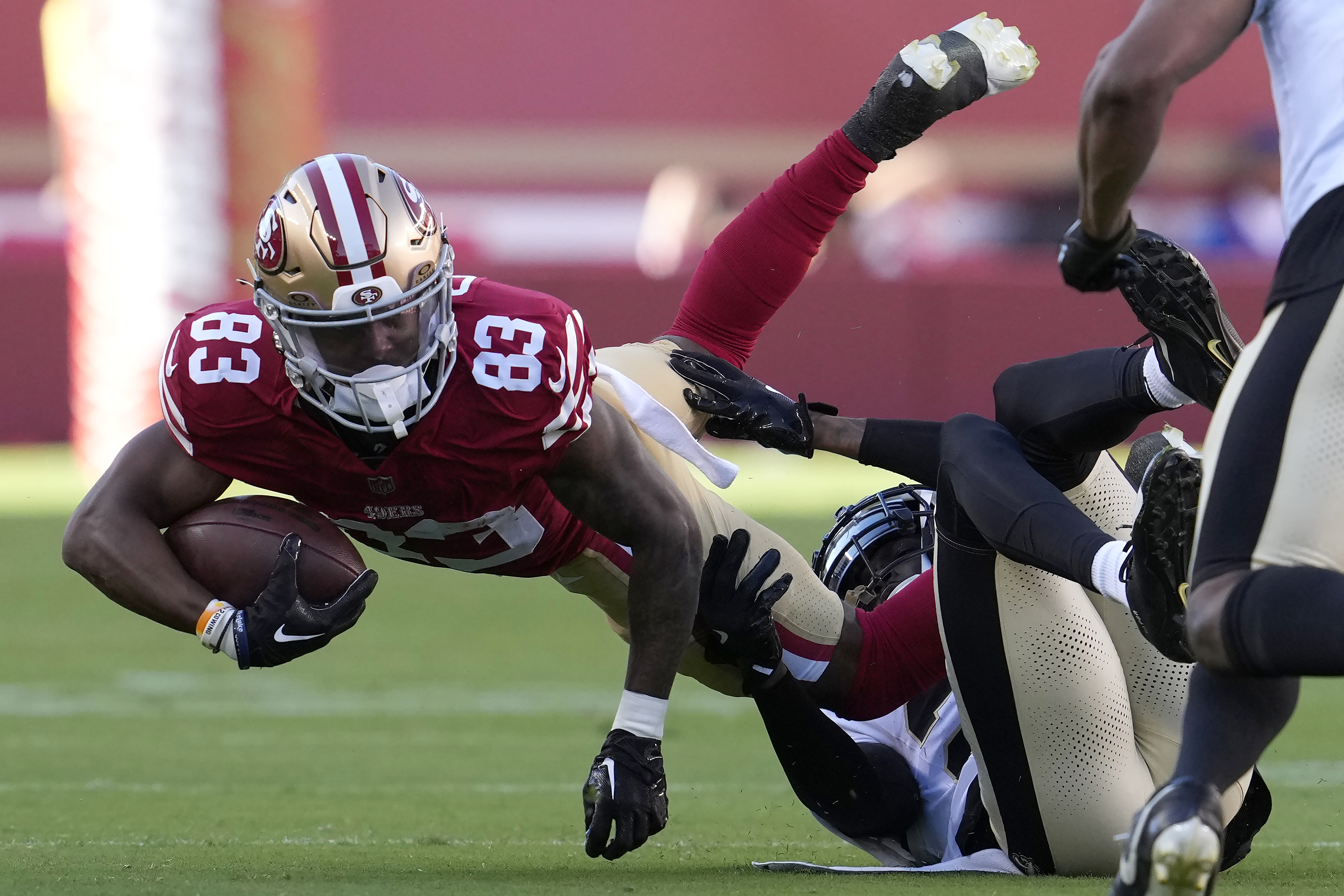 San Francisco 49ers wide receiver Jacob Cowing (83) is tackled by New Orleans Saints cornerback Rejzohn Wright during the first half of a preseason NFL football game in Santa Clara, Calif., Sunday, Aug. 18, 2024. 