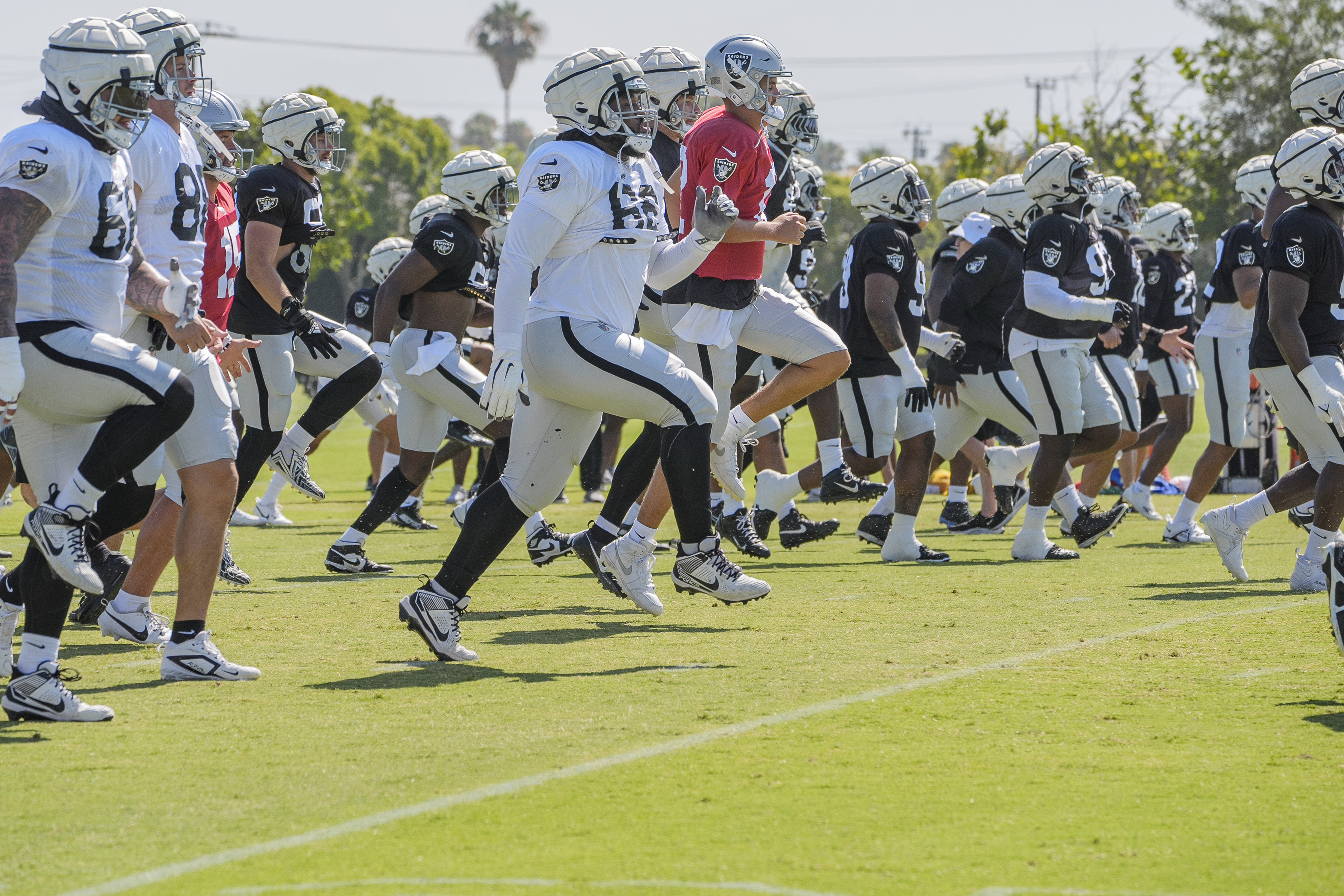 Las Vegas Raiders players warms up during an NFL football training camp in Costa Mesa, Calif., Tuesday, July 30, 2024. 