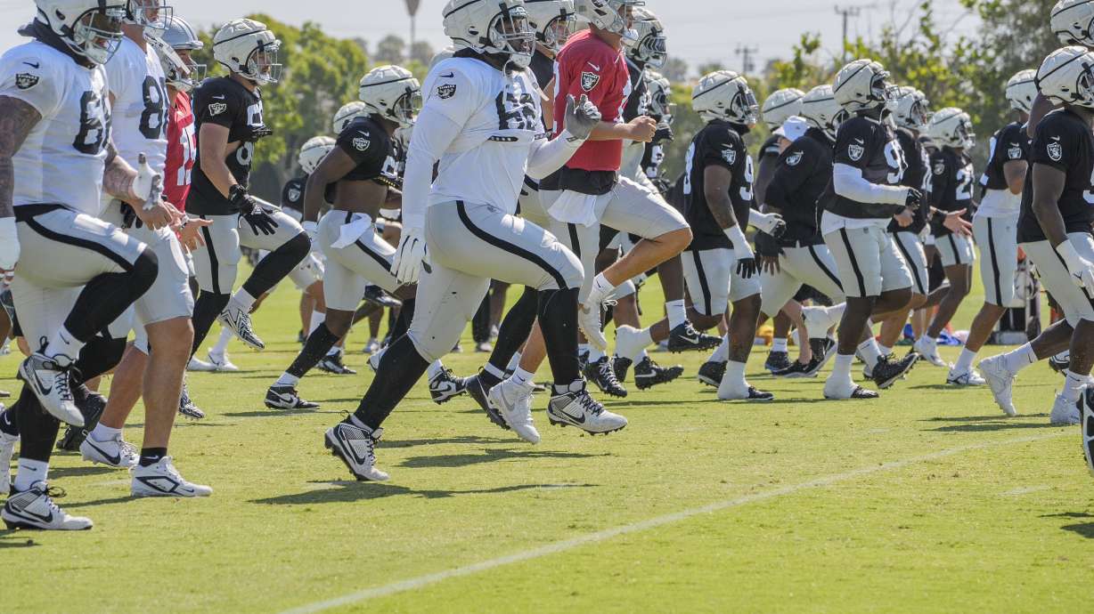 Las Vegas Raiders players warms up during an NFL football training camp in Costa Mesa, Calif., Tuesday, July 30, 2024.