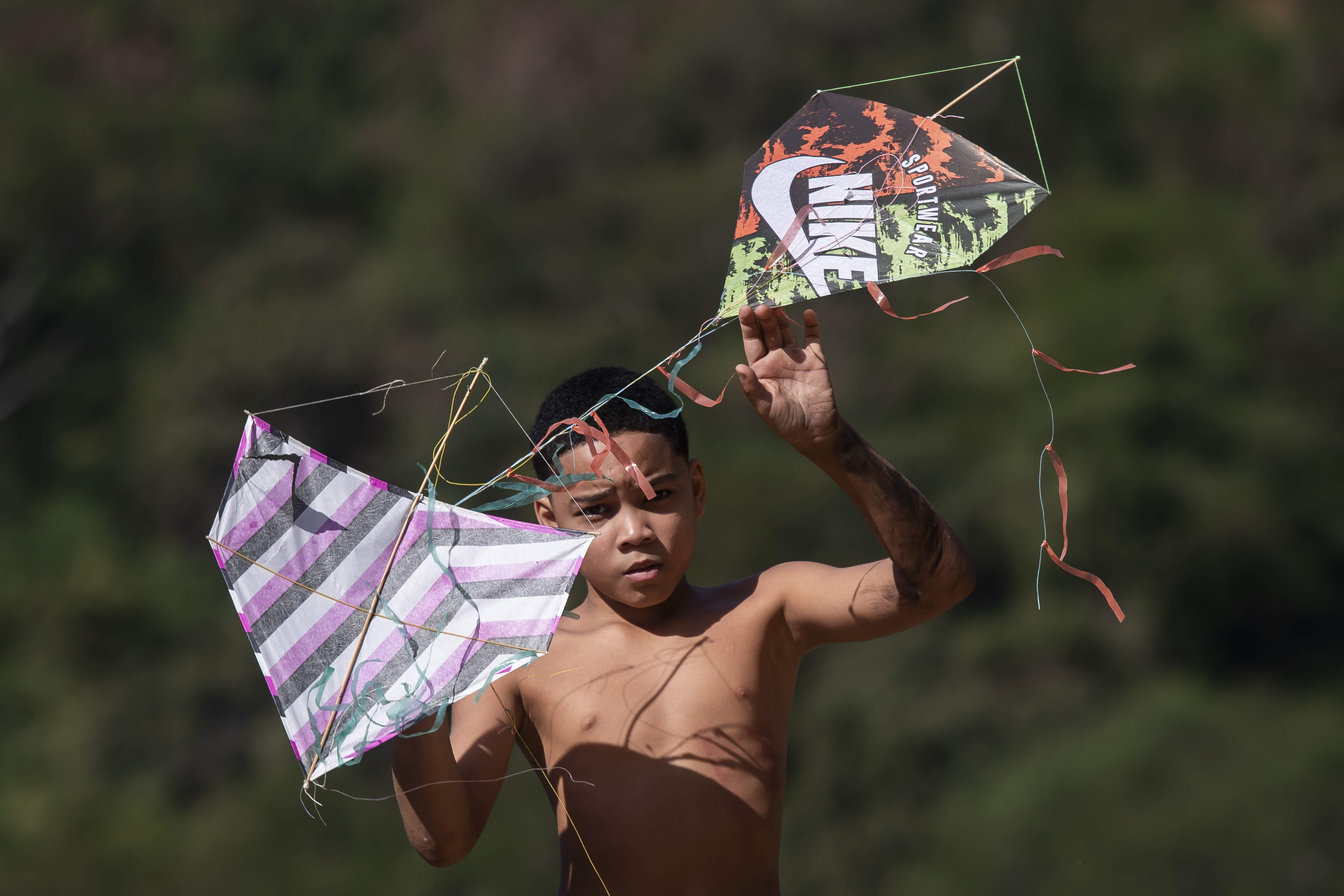 A youth holds kites during a festival in the Turano favela in Rio de Janeiro, Sunday, July 7, 2024. 
