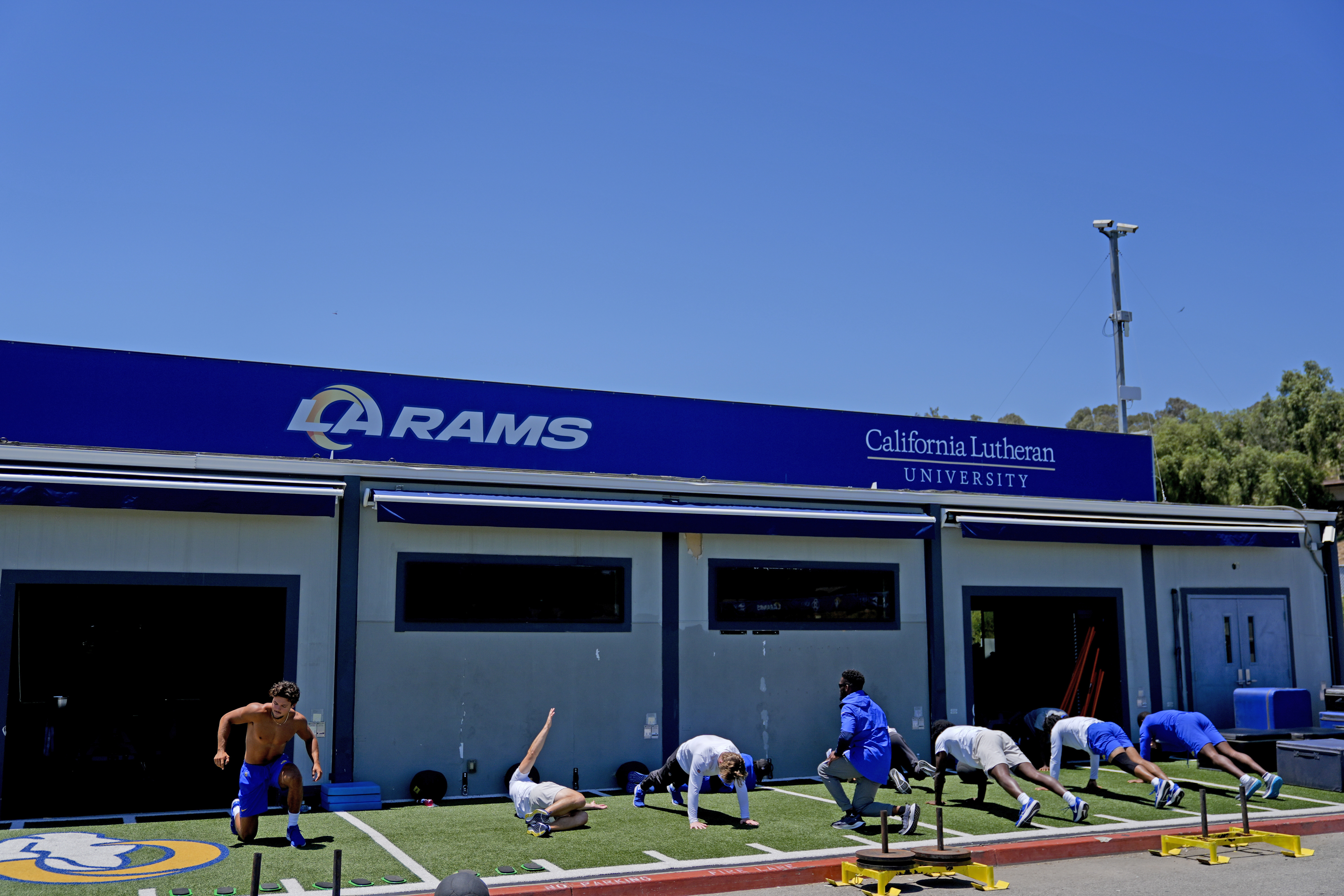 FILE - The Los Angeles Rams stretch during an NFL football practice, June 11, 2024, in Thousand Oaks, Calif. 