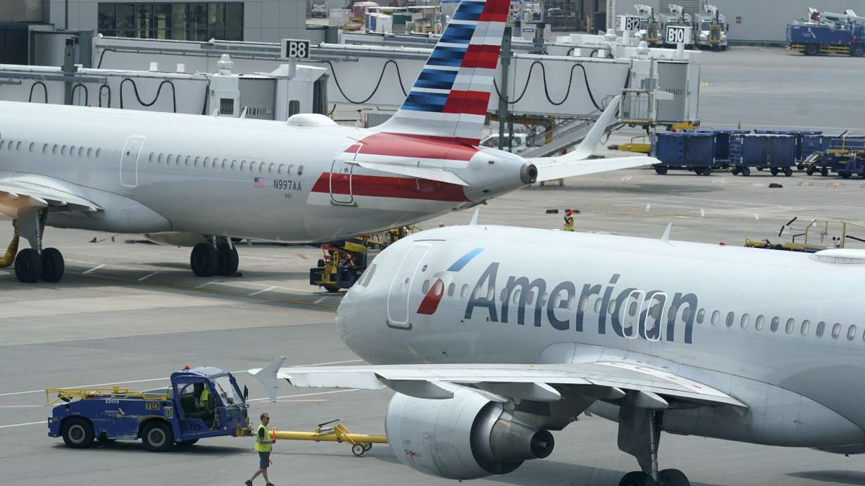 American Airlines passenger jets prepare for departure, July 21, 2021, near a terminal at Boston Logan International Airport in Boston.