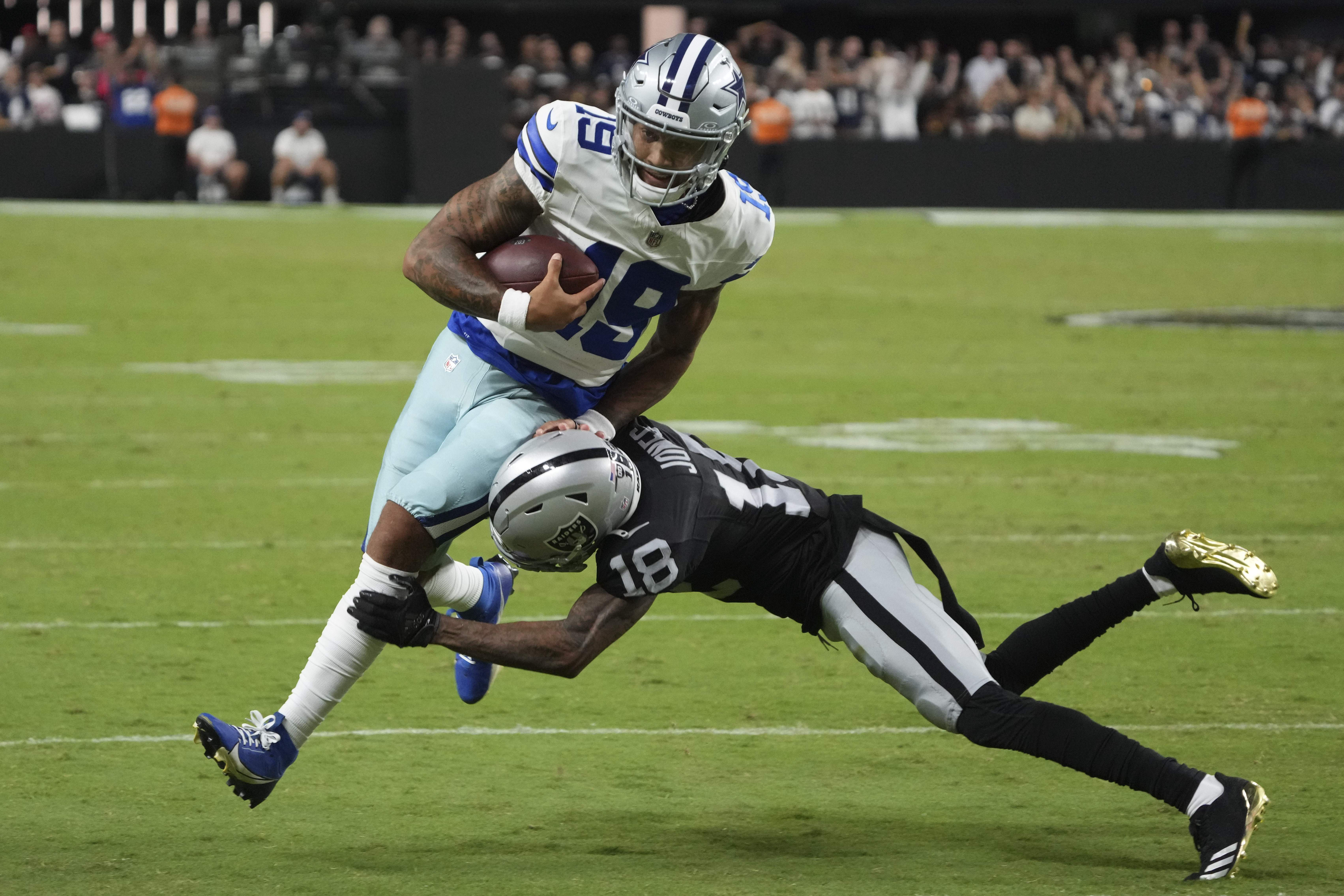Dallas Cowboys quarterback Trey Lance is tackles by Las Vegas Raiders cornerback Jack Jones (18) during the first half of an NFL preseason football game, Saturday, Aug. 17, 2024, in Las Vegas. 