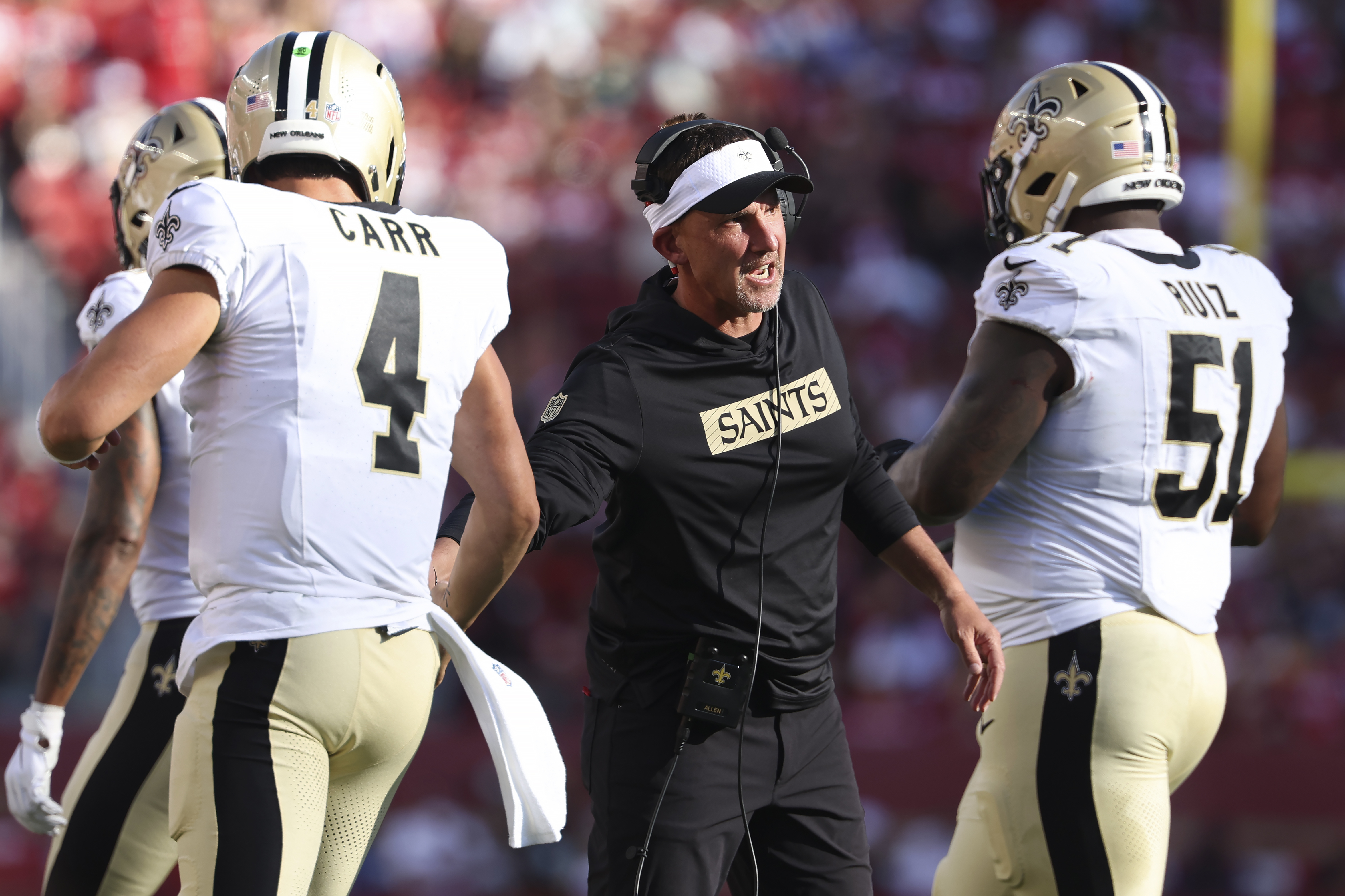 New Orleans Saints head coach Dennis Allen, middle, celebrates with quarterback Derek Carr (4) and center Cesar Ruiz (51) during the first half of a preseason NFL football game against the San Francisco 49ers in Santa Clara, Calif., Sunday, Aug. 18, 2024. 