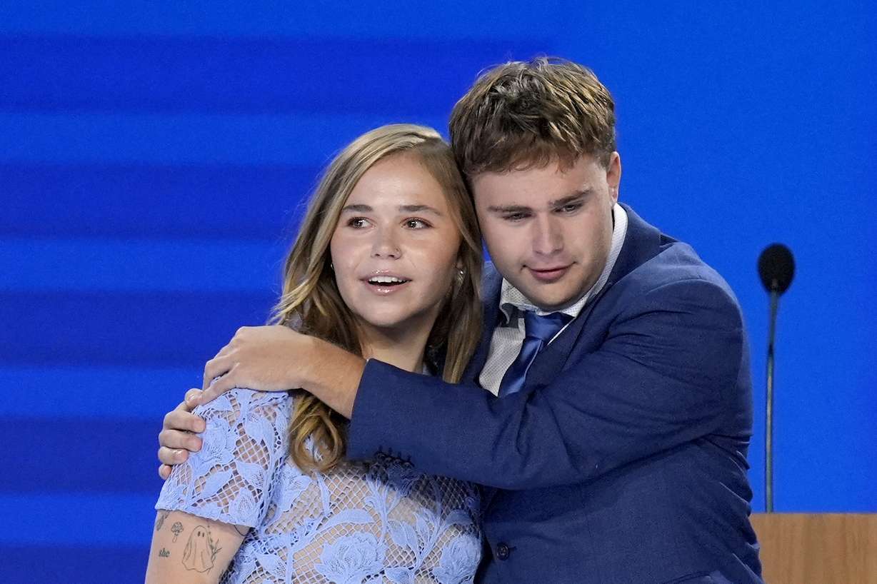 Hope Walz, left, and Gus Walz, children of Democratic vice presidential nominee Minnesota Gov. Tim Walz, right, hug after their father concludes a speech during the Democratic National Convention Wednesday, in Chicago.