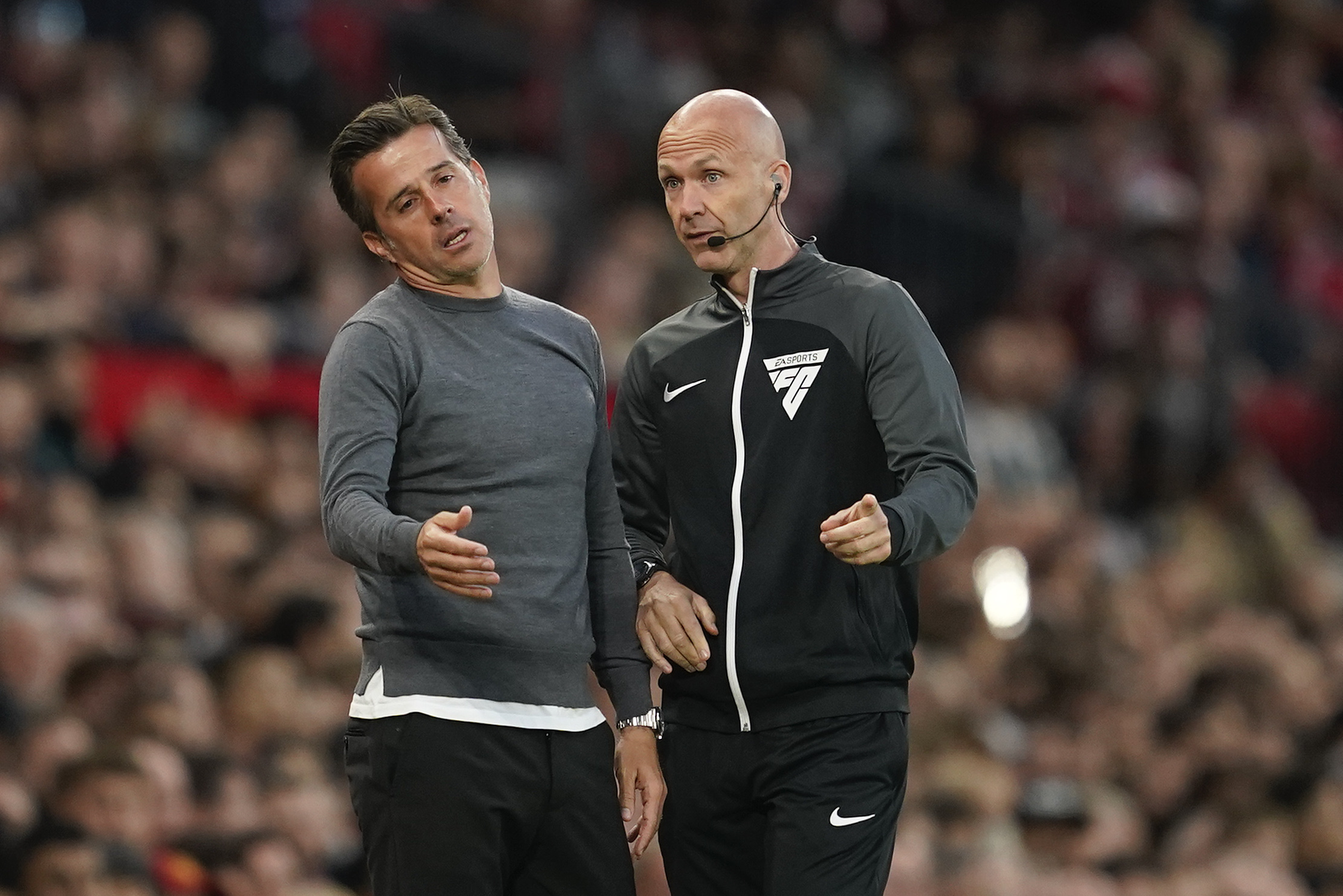 Fulham's head coach Marco Silva, left, reacts as he talks with an official during the English Premier League soccer match between Manchester United and Fulham at Old Trafford, Friday, Aug. 16, 2024, in Manchester, England. 