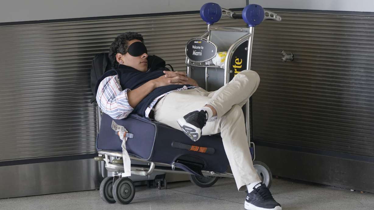 A traveler takes a nap outside Miami International Airport, July 1, 2022, in Miami. An afternoon nap can be refreshing, but experts say it also can help you at work.