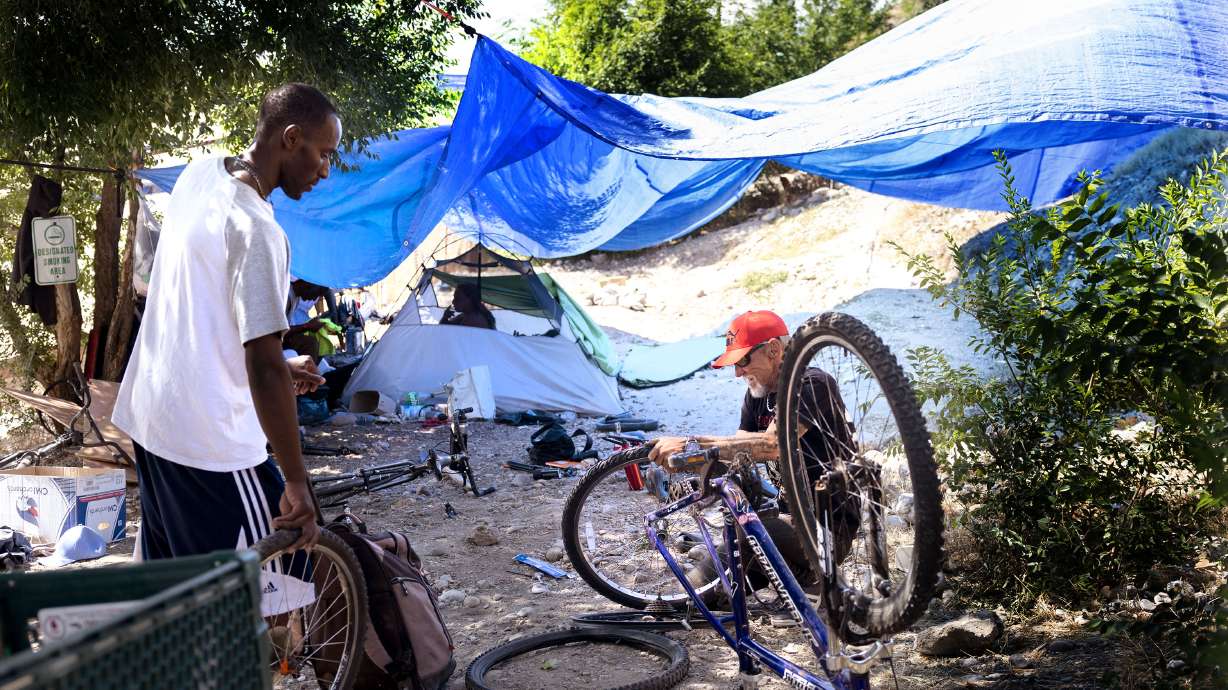 Gucci and Tennessee repair bicycles in a homeless camp in Salt Lake City. The Utah Department of Health and Human Services released the first-ever Utah homeless mortality report last week.
