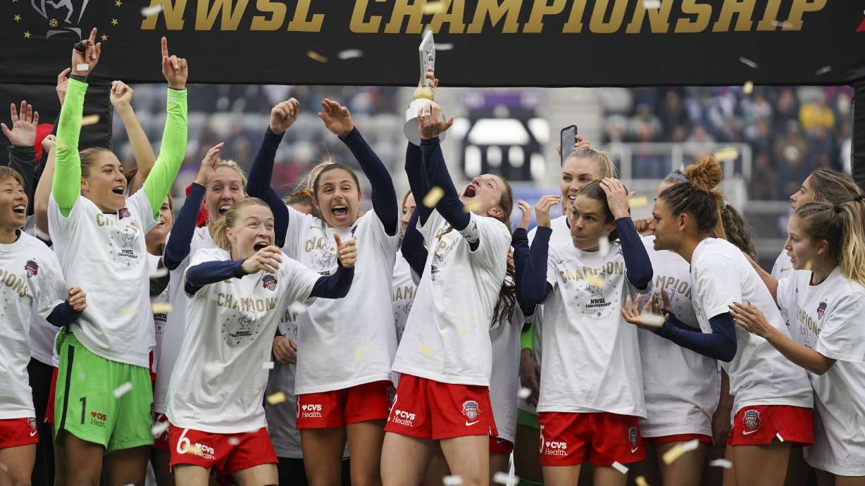 FILE - Washington Spirit's Andi Sullivan, center, lifts the trophy as they celebrate after defeating the Chicago Red Stars in the NWSL Championship soccer match, Saturday, Nov. 20, 2021, in Louisville, Ky.