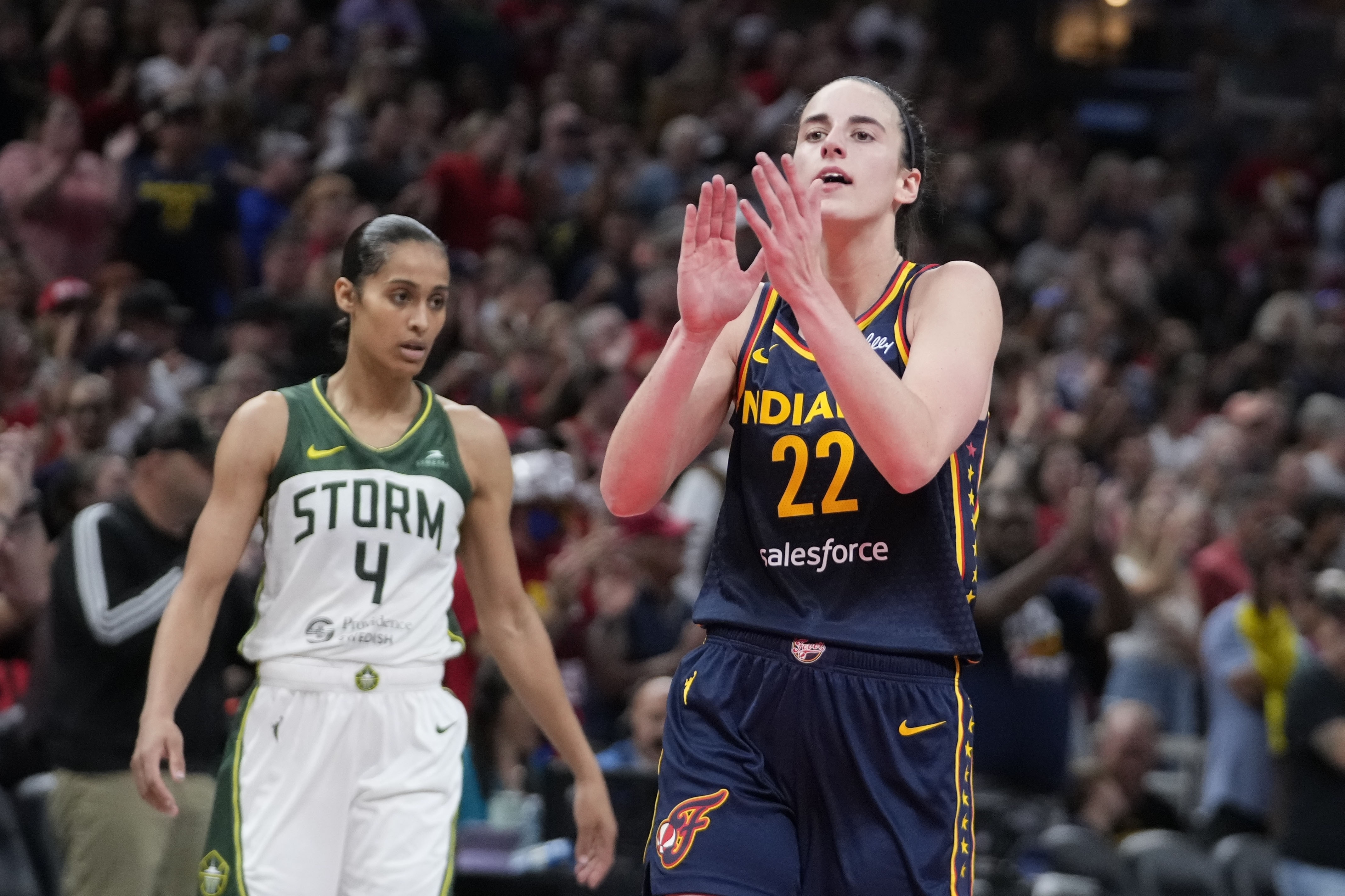 Indiana Fever's Caitlin Clark (22) reacts in front of Seattle Storm's Skylar Diggins-Smith (4) during the second half of a WNBA basketball game, Sunday, Aug. 18, 2024, in Indianapolis. 