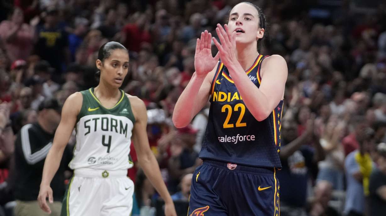 Indiana Fever's Caitlin Clark (22) reacts in front of Seattle Storm's Skylar Diggins-Smith (4) during the second half of a WNBA basketball game, Sunday, Aug. 18, 2024, in Indianapolis.