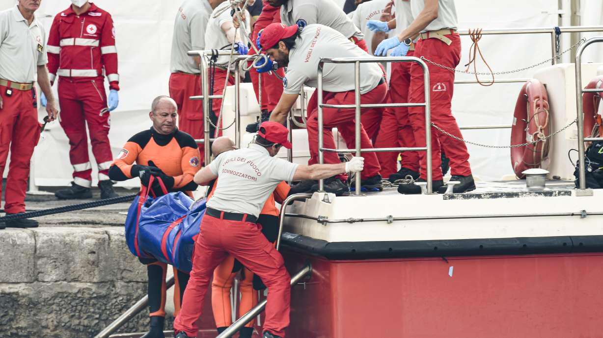 Italian firefighter divers bring ashore in a plastic bag the body of one of the victims of a shipwreck, in Porticello, Sicily, southern Italy, Thursday.