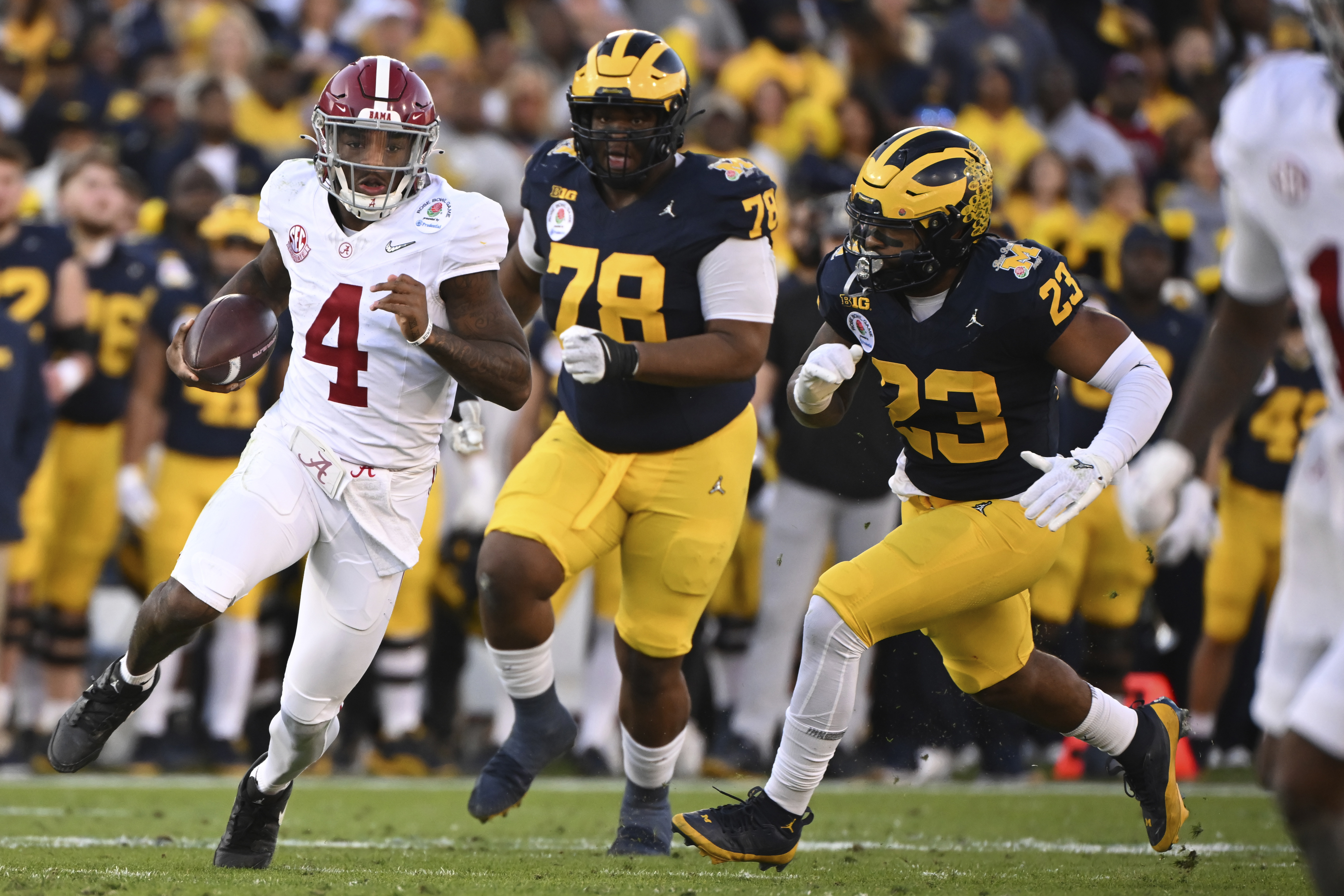 FILE - Alabama quarterback Jalen Milroe (4) runs past Michigan defensive lineman Kenneth Grant (78) and linebacker Michael Barrett (23) during the first half of the Rose Bowl CFP NCAA semifinal college football game Monday, Jan. 1, 2024, in Pasadena, Calif.
