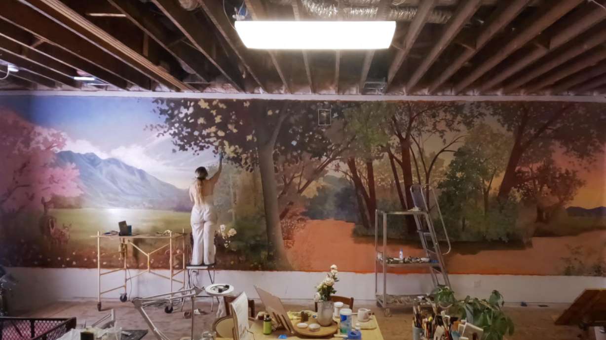 Courtney Hart works on a springtime landscape mural for the Provo Airport.