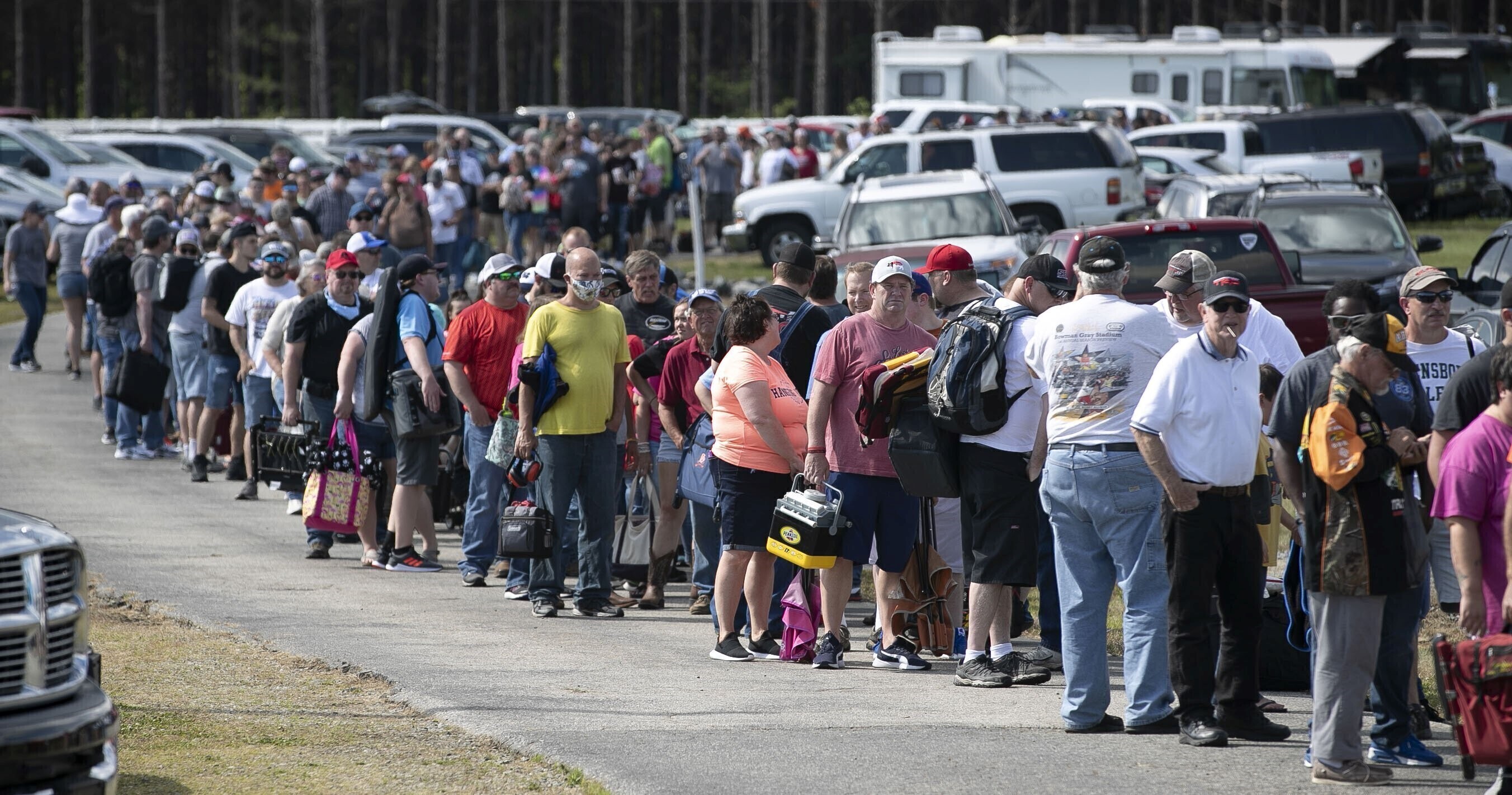 FILE - Hundreds of race fans wait in line to purchase tickets at the Ace Speedway in the rural Alamance County community of Altamahaw near Elon, N.C., on May 23, 2020. 