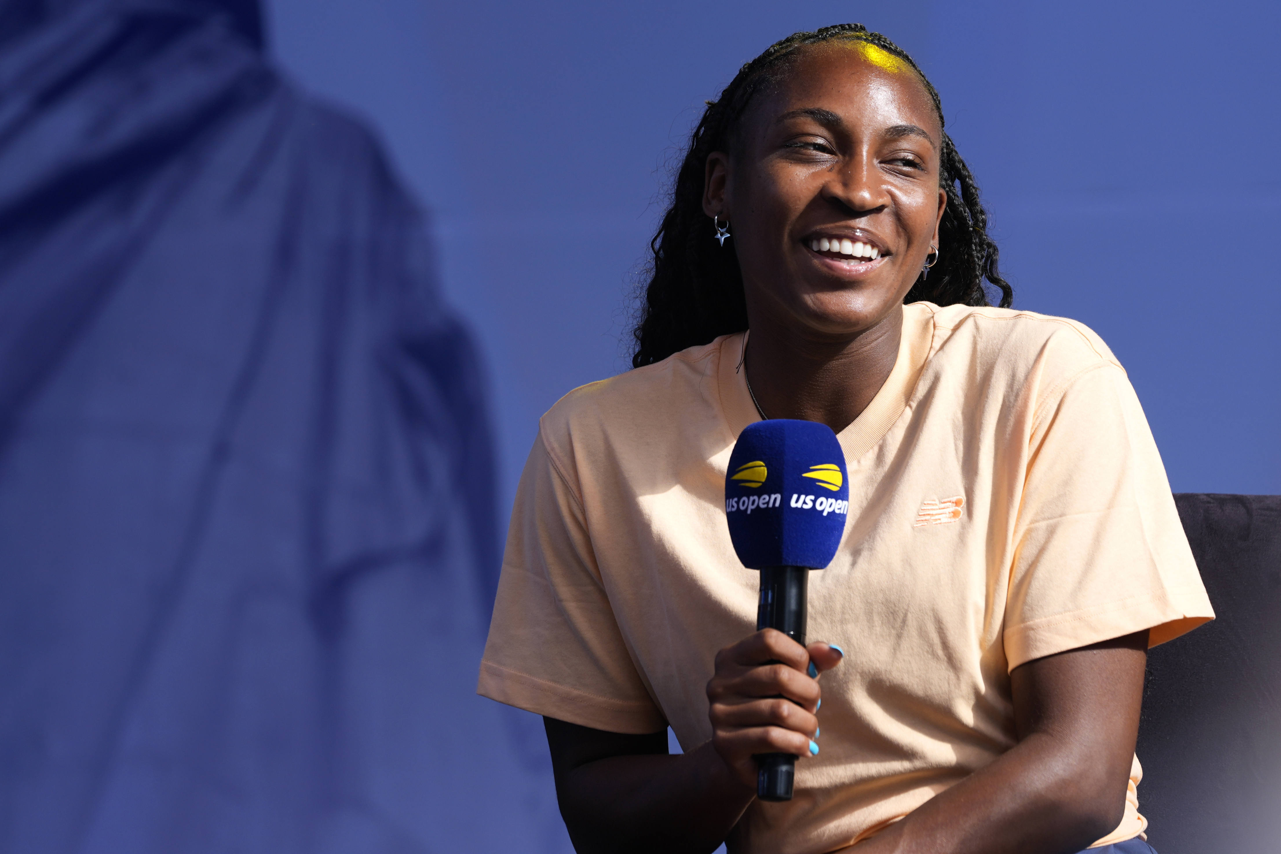 Coco Gauff smiles while speaking to the crowd at the US Open Fan Week at the USTA Billie Jean King National Tennis Center in New York, Tuesday, Aug. 20, 2024. 