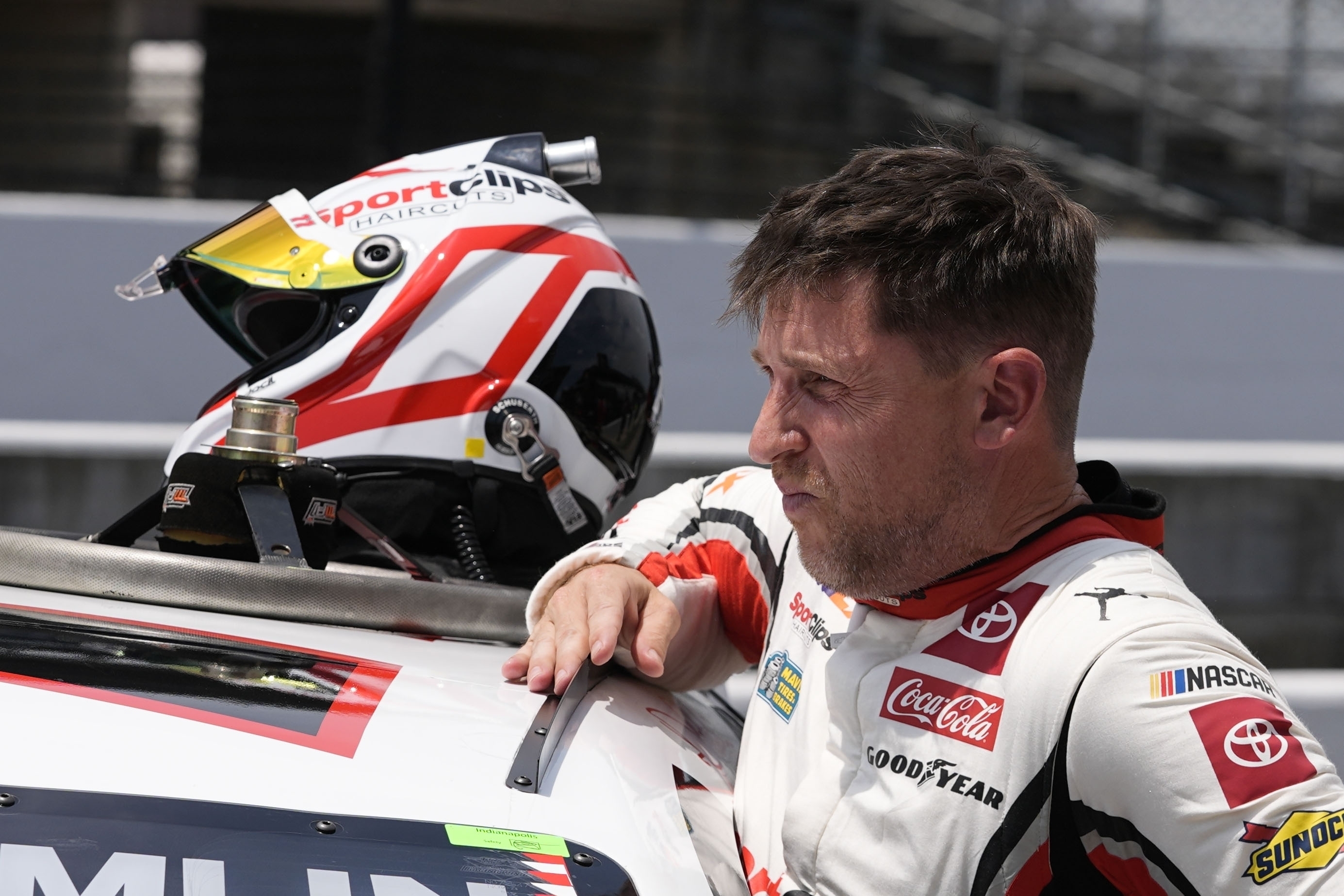 FILE - Denny Hamlin climbs out of his car during qualifications for the NASCAR Cup Series auto race at Indianapolis Motor Speedway, Saturday, July 20, 2024, in Indianapolis.