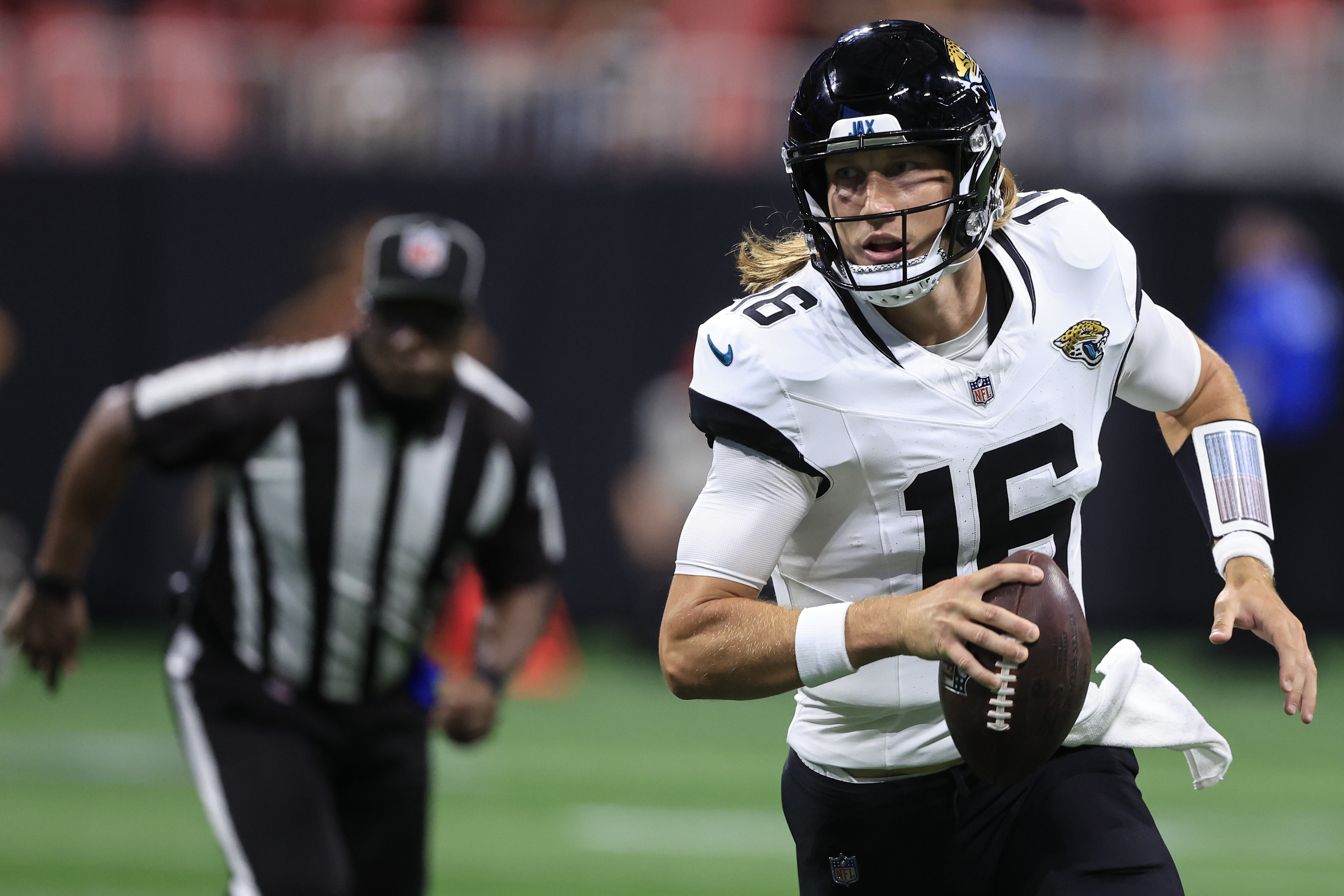Jacksonville Jaguars quarterback Trevor Lawrence (16) runs out of the pocket against the Atlanta Falcons in the first half of an NFL preseason footballl game, Friday, Aug. 23, 2024, in Atlanta. 