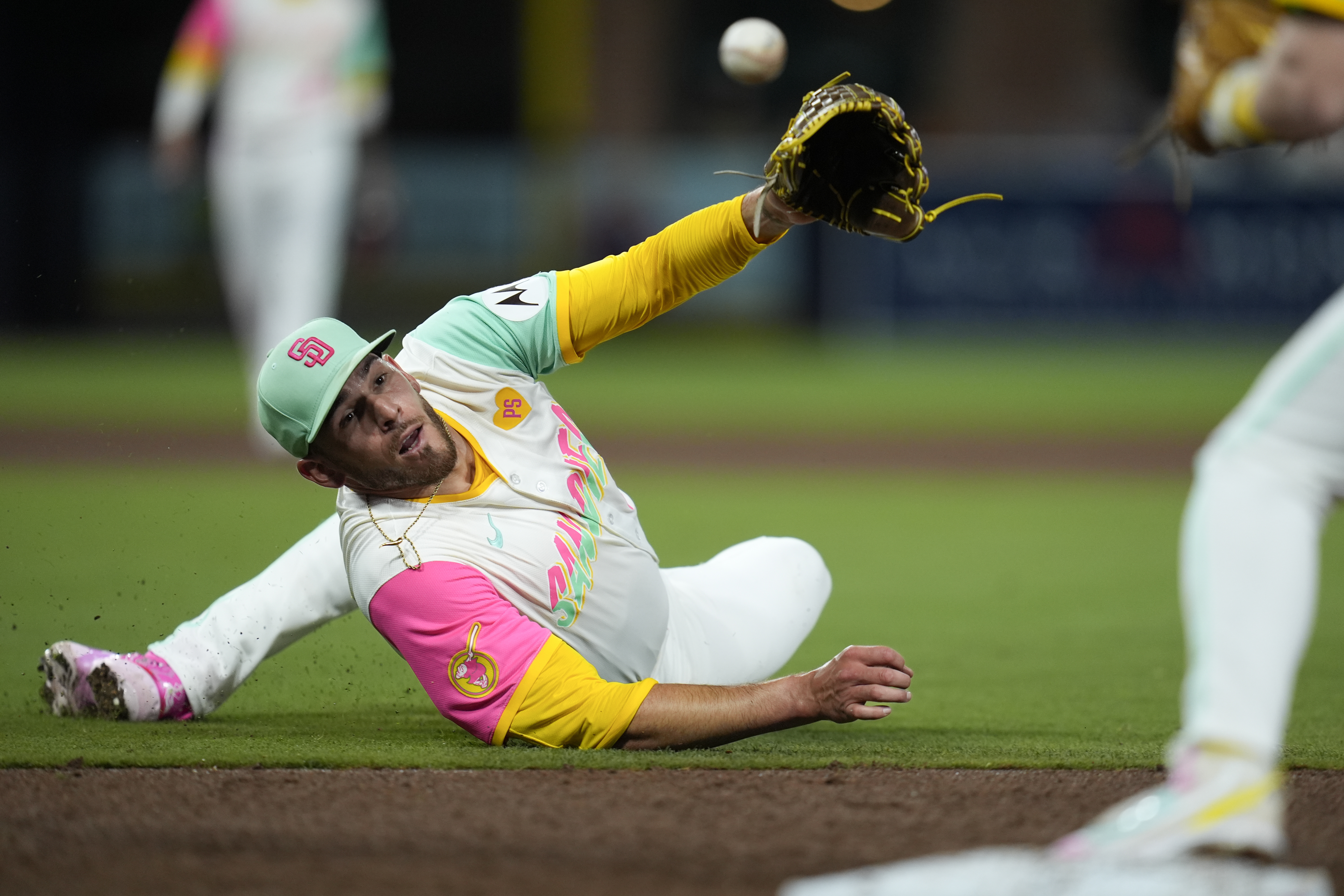San Diego Padres starting pitcher Joe Musgrove tosses the ball with his glove to first baseman Jake Cronenworth for the out on New York Mets' Francisco Lindor during the sixth inning of a baseball game Friday, Aug. 23, 2024, in San Diego. 