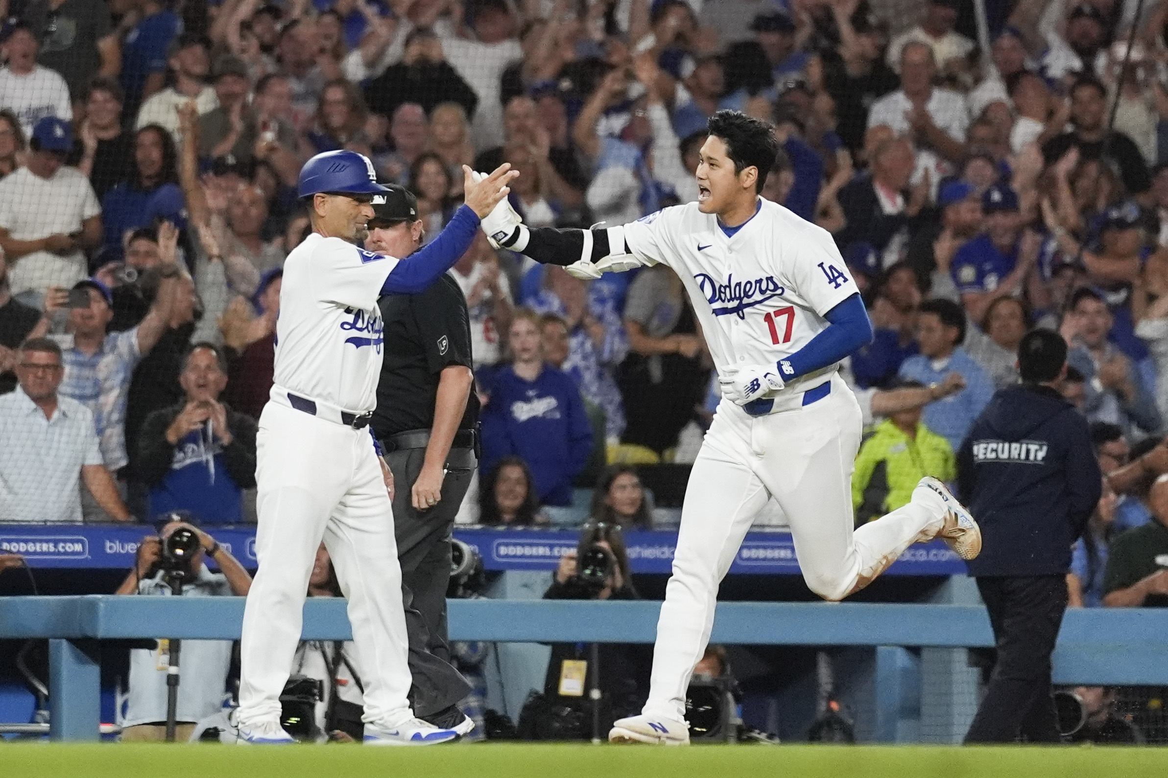 Los Angeles Dodgers designated hitter Shohei Ohtani (17) greets third base coach Dino Ebel as he runs the bases after hitting a grand slam during the ninth inning of a baseball game against the Tampa Bay Rays in Los Angeles, Friday, Aug. 23, 2024. The Dodgers won 7-3. Will Smith, Tommy Edman, and Max Muncy also scored. 