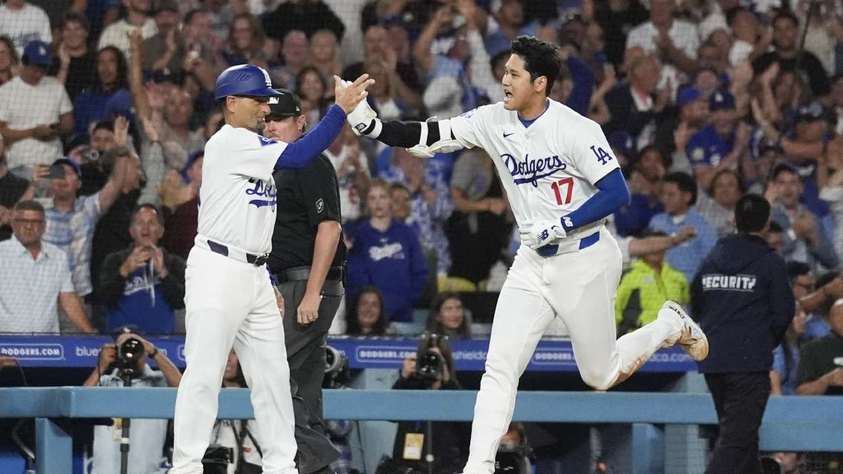 Los Angeles Dodgers designated hitter Shohei Ohtani (17) greets third base coach Dino Ebel as he runs the bases after hitting a grand slam during the ninth inning of a baseball game against the Tampa Bay Rays in Los Angeles, Friday, Aug. 23, 2024. The Dodgers won 7-3. Will Smith, Tommy Edman, and Max Muncy also scored.