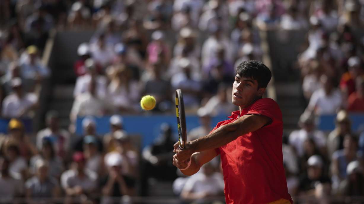Spain's Carlos Alcaraz backhands to Serbia's Novak Djokovic during the men's singles tennis final at the Roland Garros stadium during the 2024 Summer Olympics, Sunday, Aug. 4, 2024, in Paris, France.