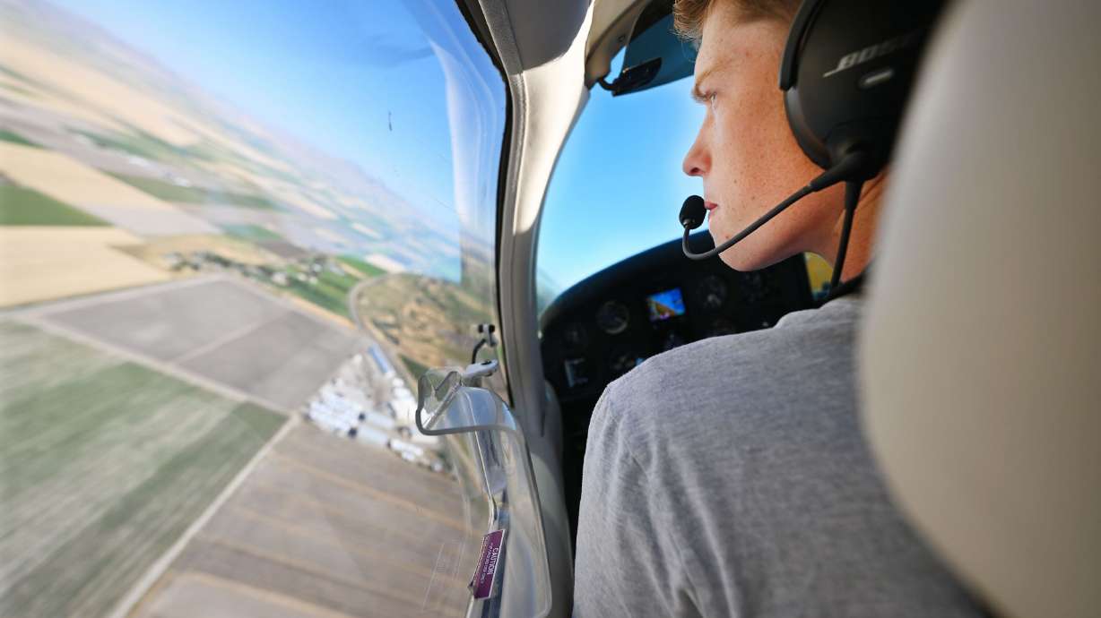 Mason Bingham, a student at Box Elder High training to become a pilot through Utah State University’s Private Pilot Ground School program, looks out toward the ground for a landmark as he and his instructor, who is also his father Jason Bingham fly over the Brigham City area on Aug. 16.