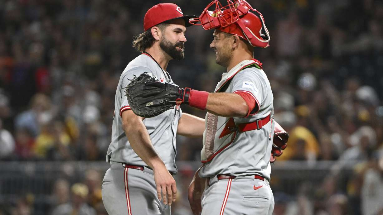 Cincinnati Reds relief pitcher Casey Kelly celebrates with catcher Luke Maile after defeating the Pittsburgh Pirates 10-2 during a baseball game, Saturday, Aug. 24, 2024, in Pittsburgh.
