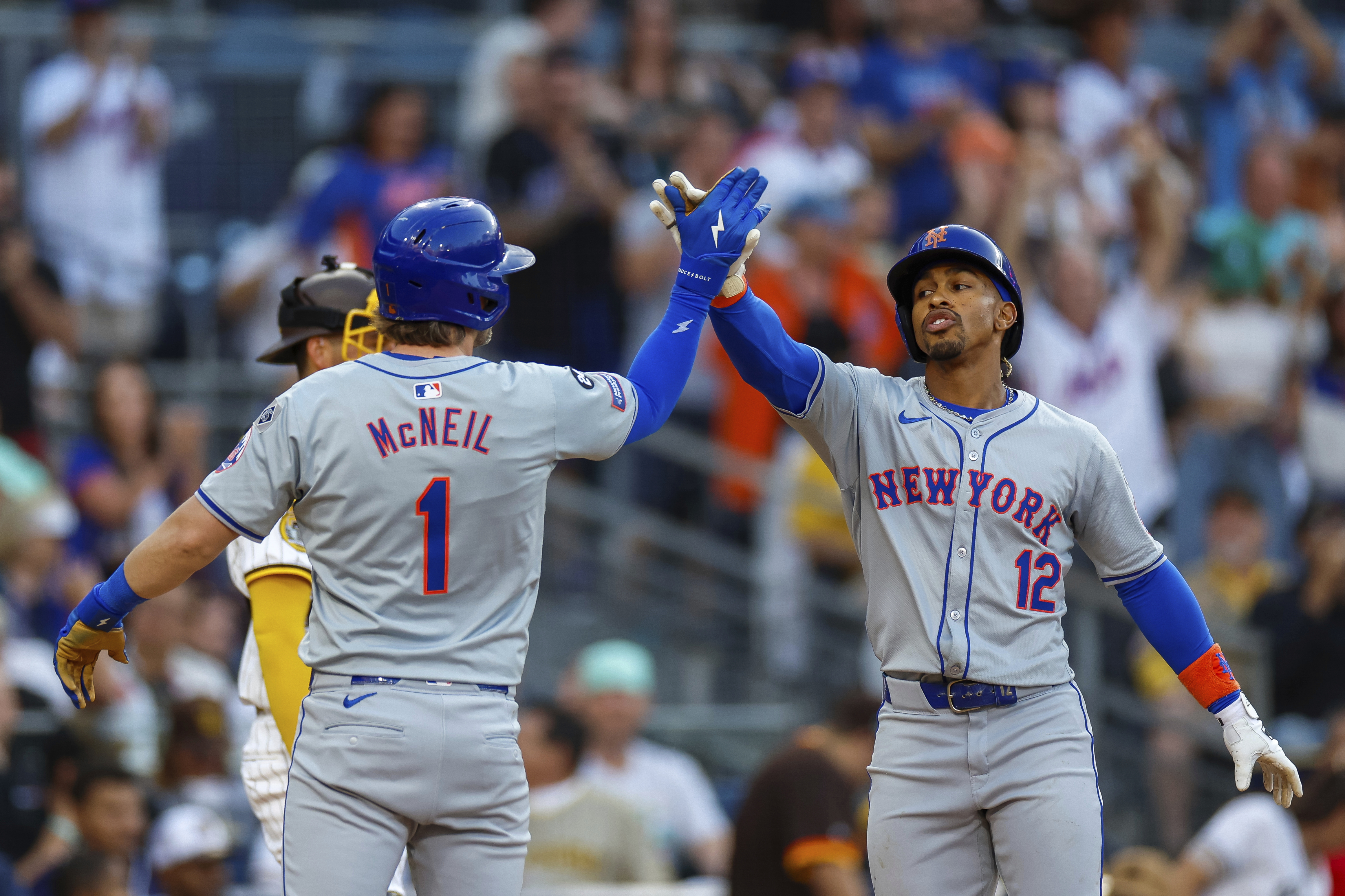 New York Mets' Francisco Lindor (12) celebrates with Jeff McNeil (1) after hitting a grand slam during the fourth inning of a baseball game against the San Diego Padres, Saturday, Aug. 24, 2024, in San Diego.