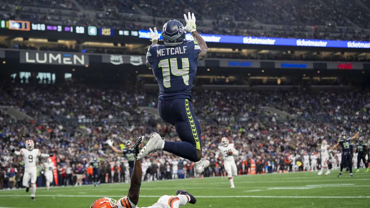 Seattle Seahawks wide receiver DK Metcalf (14) makes a catch for a touchdown over Cleveland Browns cornerback Justin Hardee Sr., bottom, during the first half of a preseason NFL football game Saturday, Aug. 24, 2024, in Seattle.
