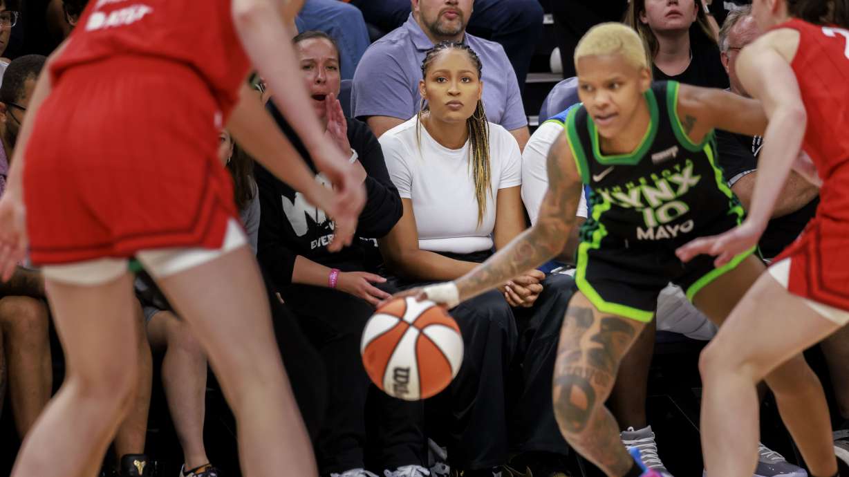 Maya Moore Irons, center, watches the WNBA basketball game between the Minnesota Lynx and the Indiana Fever on Saturday, Aug. 24, 2024, in Minneapolis.