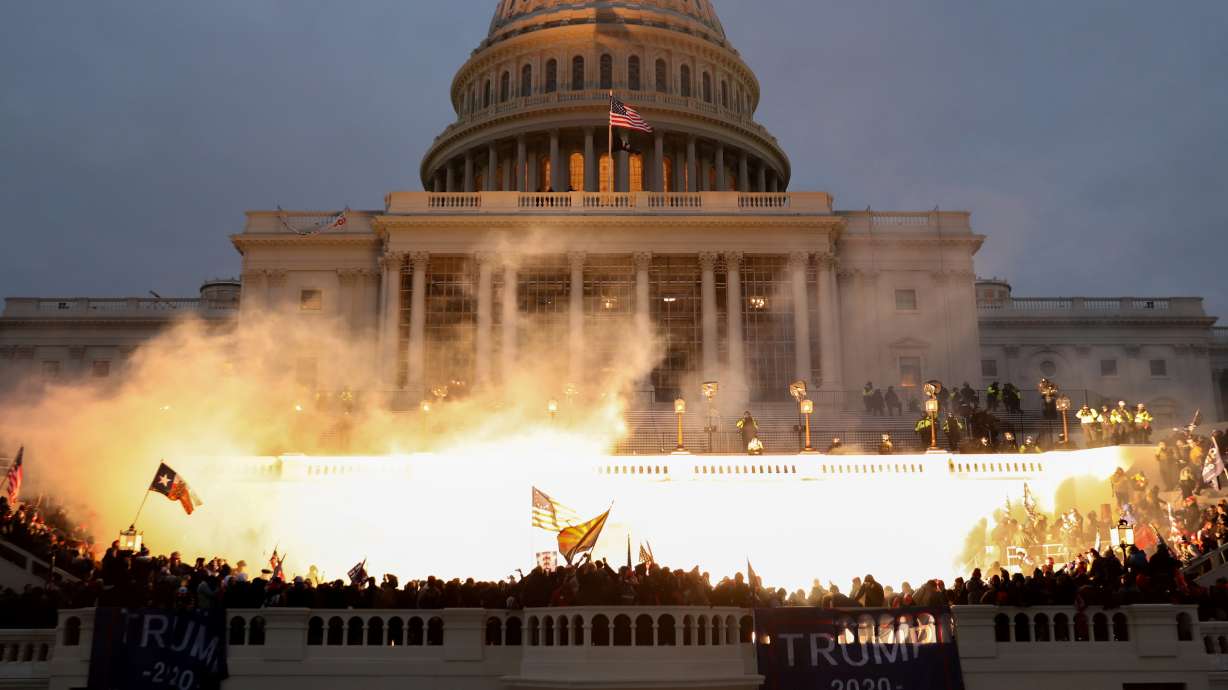 An explosion caused by a police munition is seen while supporters of U.S. President Donald Trump riot in front of the U.S. Capitol Building in Washington, Jan. 6, 2021. A new poll found most Americans fear there may be political violence before and after Election Day.