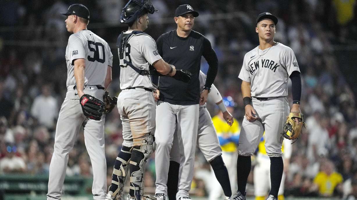 New York Yankees manager Aaron Boone, center right, stands on the mound after relieving Michael Tonkin (50) during the seventh inning of a baseball game against the Boston Red Sox, Saturday, July 27, 2024, in Boston.
