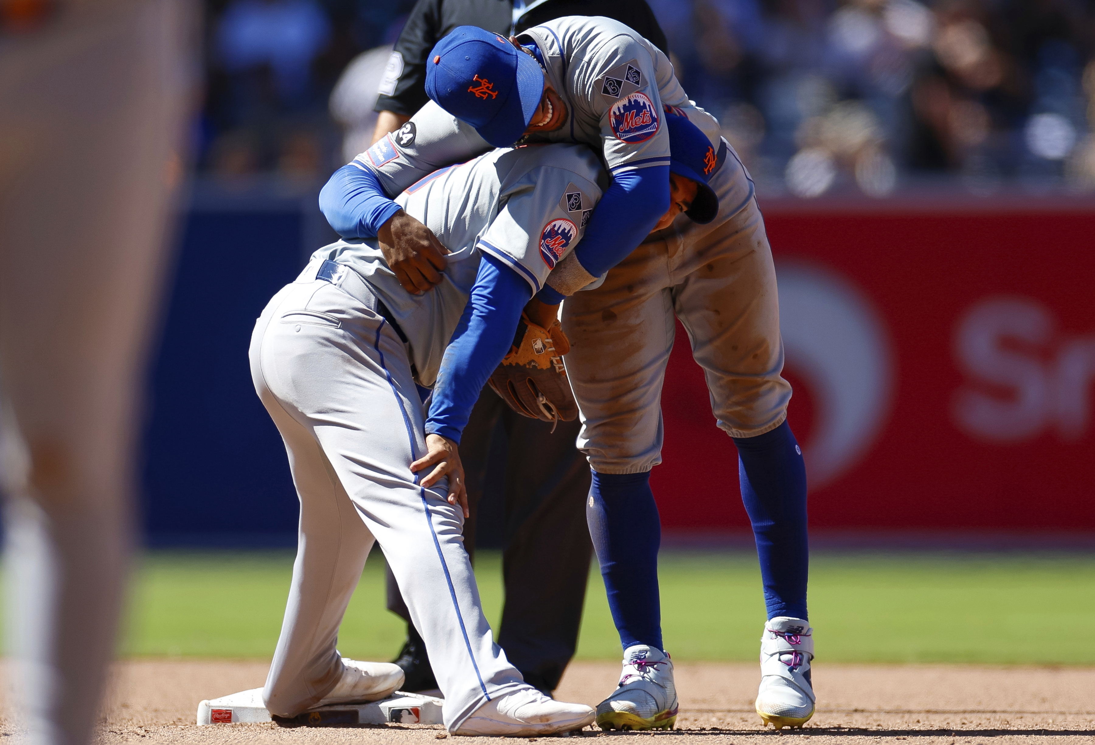 New York Mets shortstop Francisco Lindor, top, smiles with second baseman Jose Iglesias, bottom, after a force out against San Diego Padres' Jurickson Profar at second during the sixth inning of a baseball game, Sunday, Aug. 25, 2024, in San Diego. 