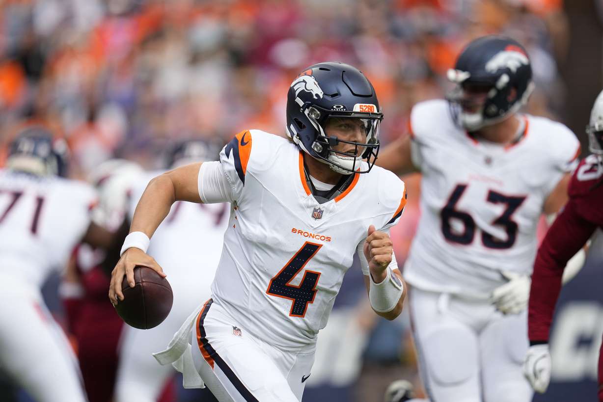 Denver Broncos quarterback Zach Wilson runs with the ball against the Arizona Cardinals during the first half of a preseason NFL football game Sunday, Aug. 25, 2024, in Denver.