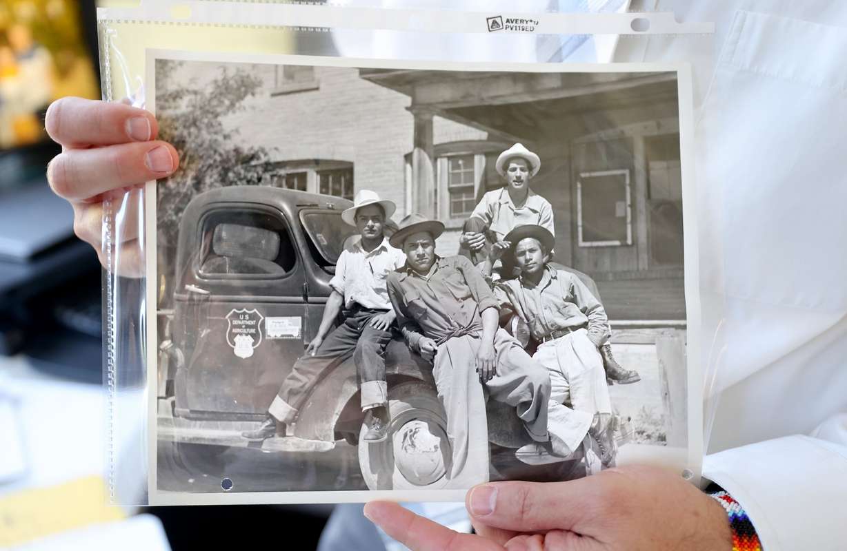 Matthew C. Godfrey, Church History Department senior managing historian of outreach and engagement, holds a 1945 photo of Mexican immigrants who came to work on a sugar beet farm in Spanish Fork, in Godfrey’s office at the Church History Library in Salt Lake City on Aug. 13.
