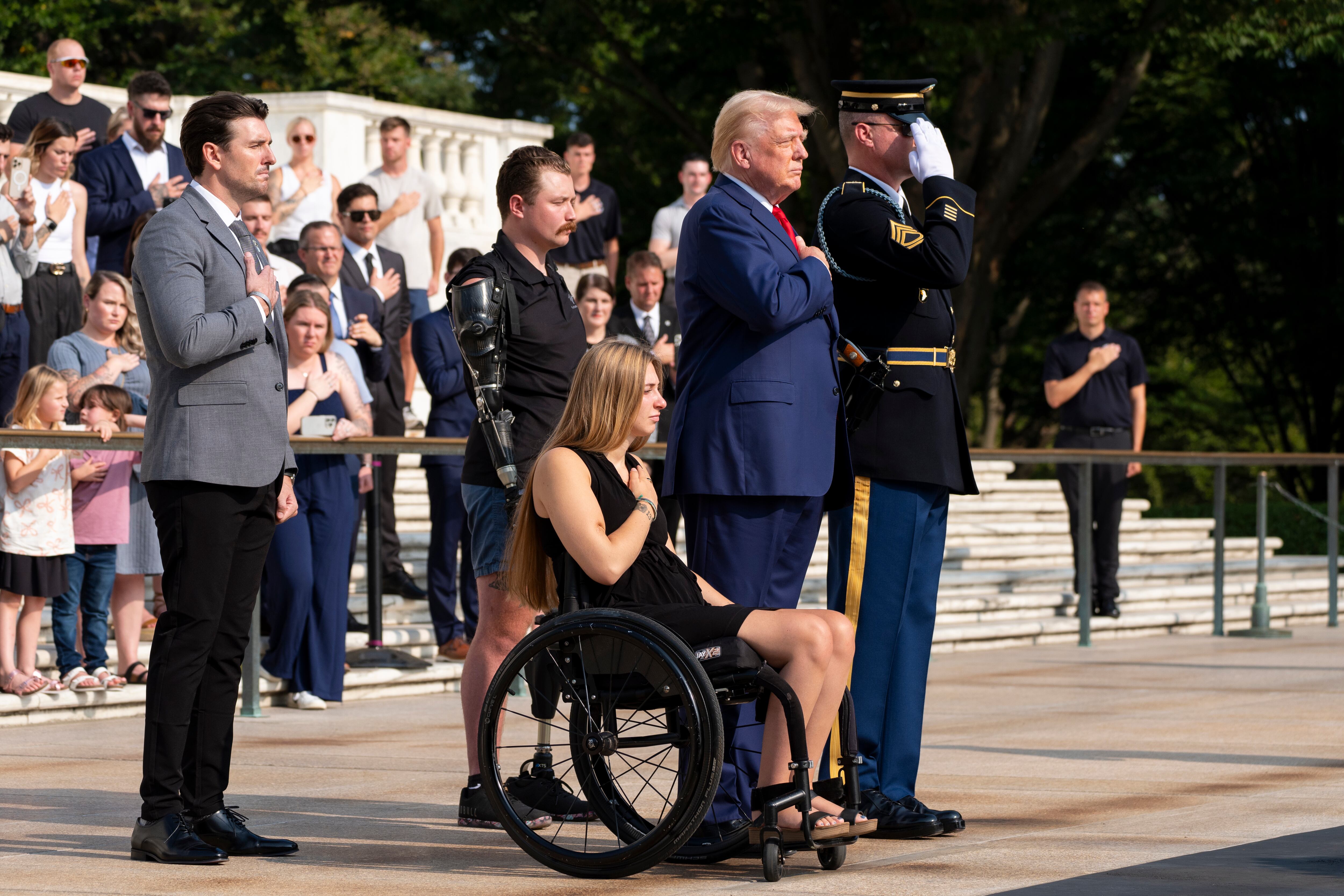 Marlon Bateman, left, former U.S. Marine Sgt. Tyler Vargas, former U.S. Marine Cpl. Kelsee Lainhart, center front, and former president Donald Trump place a wreath at the Tomb of the Unknown Solider in honor of the 13 service members killed at Abbey Gate, at Arlington National Cemetery, Monday in Arlington, Va.