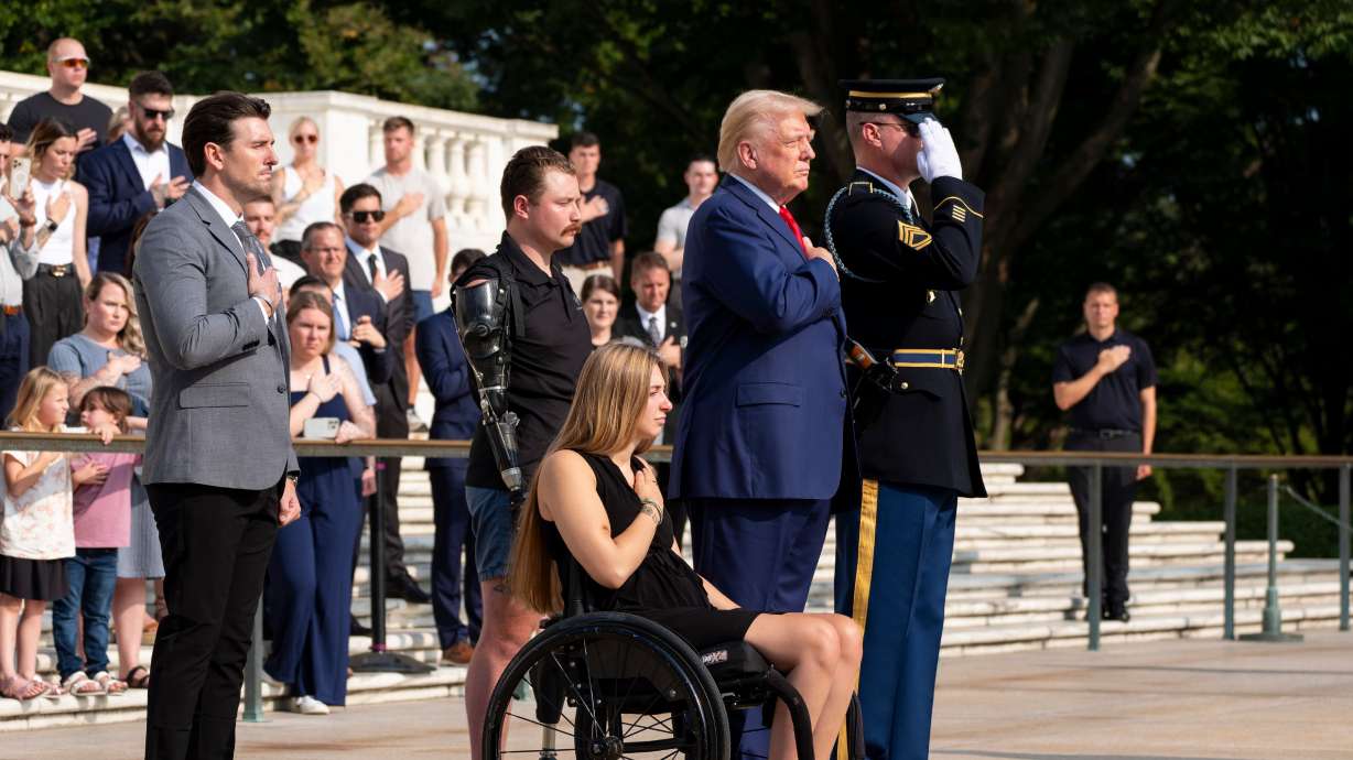 Marlon Bateman, left, former U.S. Marine Sgt. Tyler Vargas, former U.S. Marine Cpl. Kelsee Lainhart, center front, and former president Donald Trump place a wreath at the Tomb of the Unknown Solider in honor of the 13 service members killed at Abbey Gate, at Arlington National Cemetery, Monday in Arlington, Va.