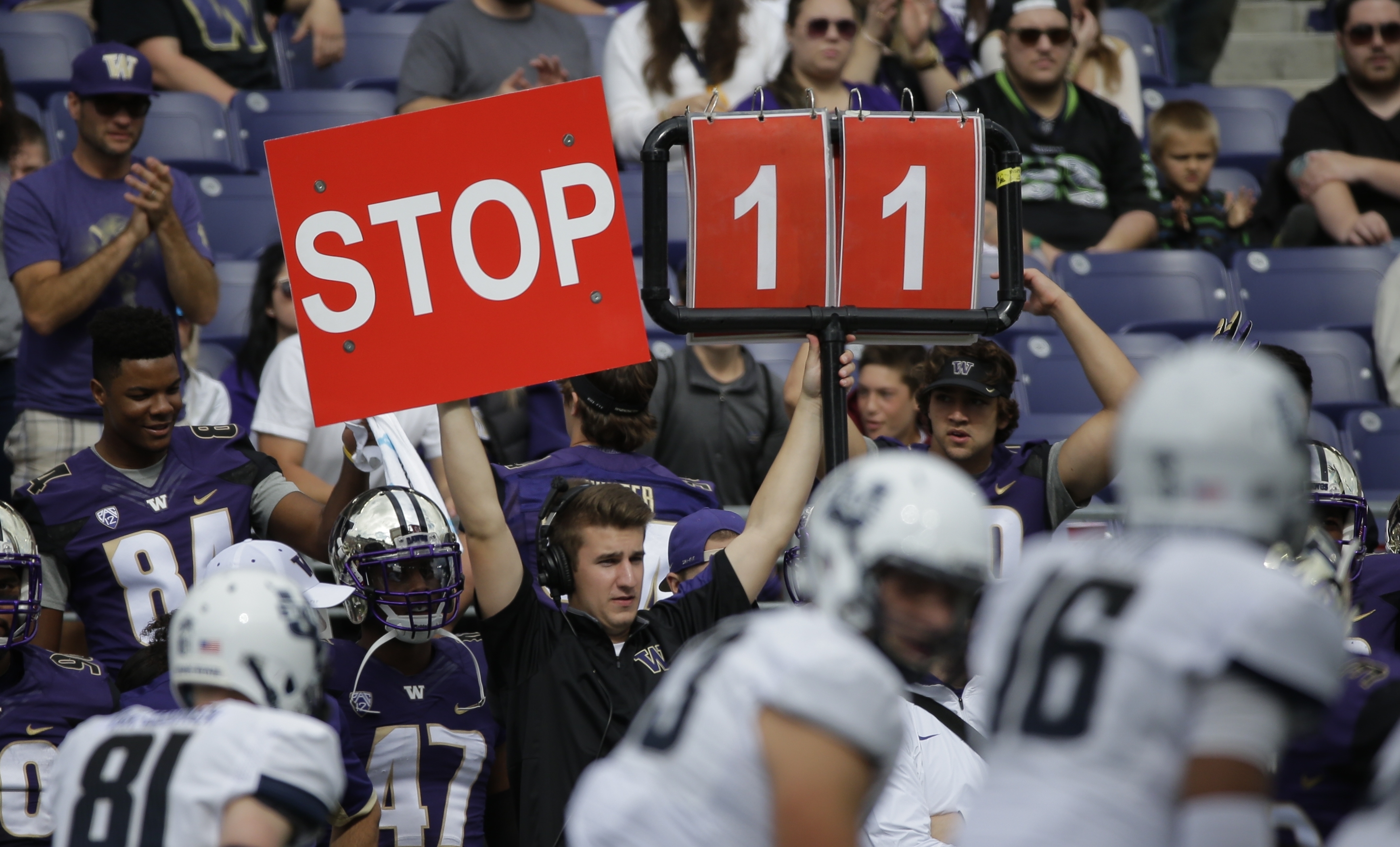 FILE - A play is signaled from the Washington sideline in the second half of an NCAA college football game against Utah State in Seattle, Sept. 19, 2015. 