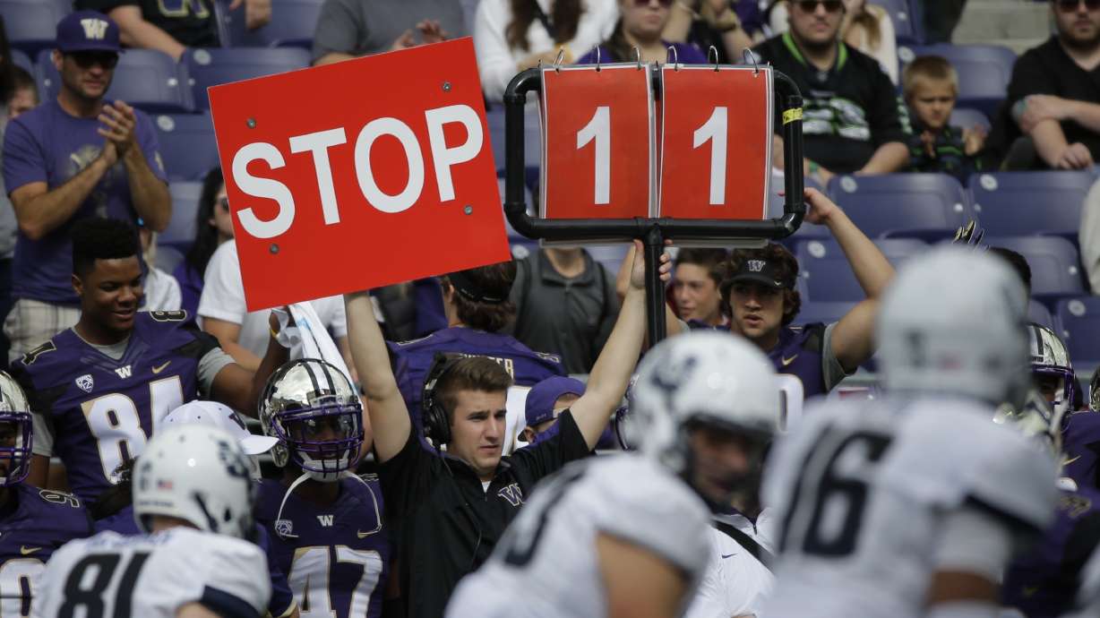 FILE - A play is signaled from the Washington sideline in the second half of an NCAA college football game against Utah State in Seattle, Sept. 19, 2015.