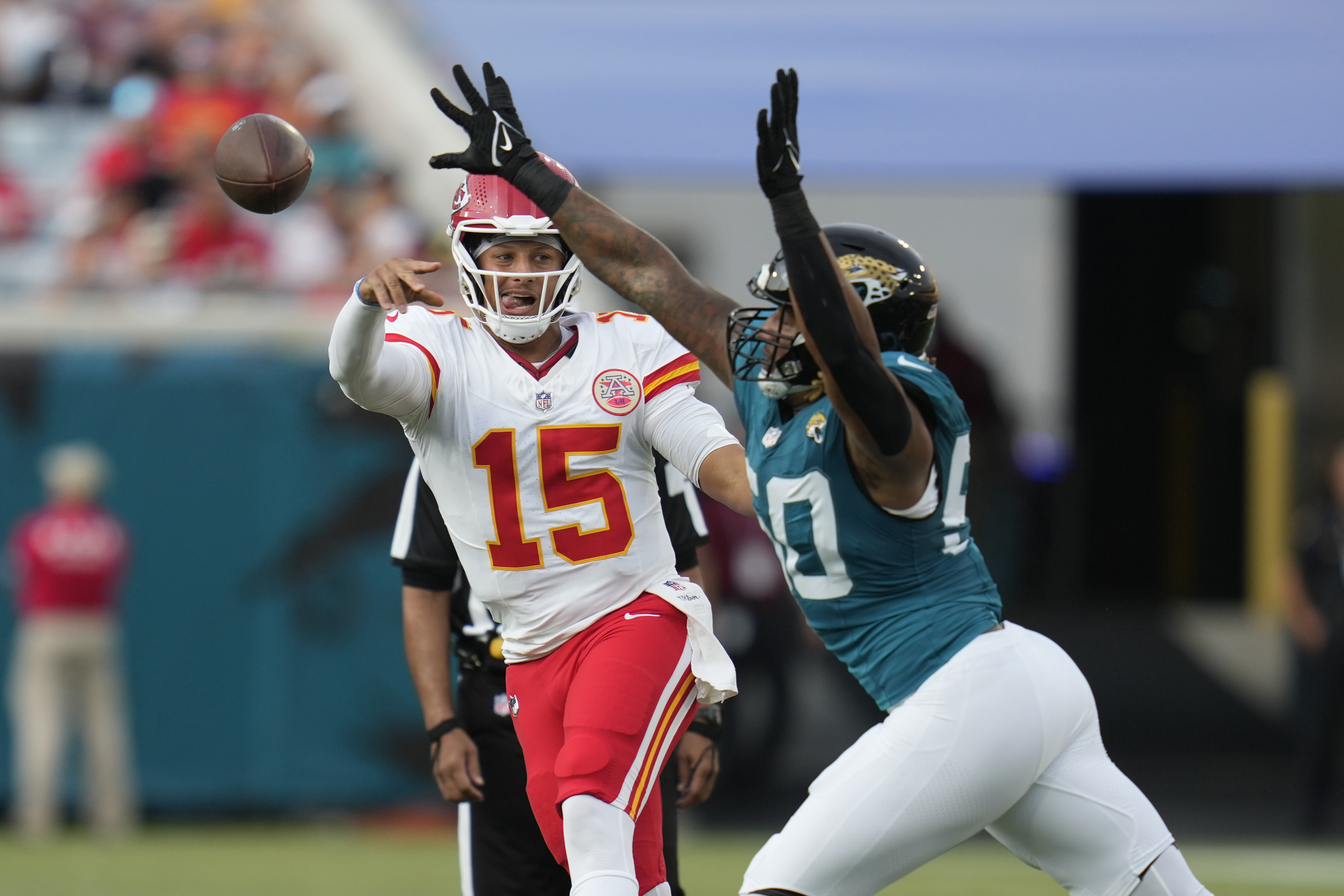 Kansas City Chiefs quarterback Patrick Mahomes (15) throws as Jacksonville Jaguars defensive end Trevis Gipson defends during the first half of an NFL preseason football game Saturday, Aug. 10, 2024, in Jacksonville, Fla. 