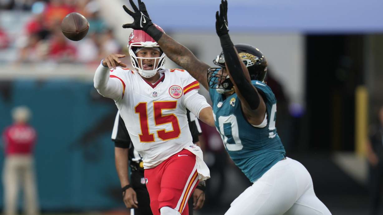 Kansas City Chiefs quarterback Patrick Mahomes (15) throws as Jacksonville Jaguars defensive end Trevis Gipson defends during the first half of an NFL preseason football game Saturday, Aug. 10, 2024, in Jacksonville, Fla.