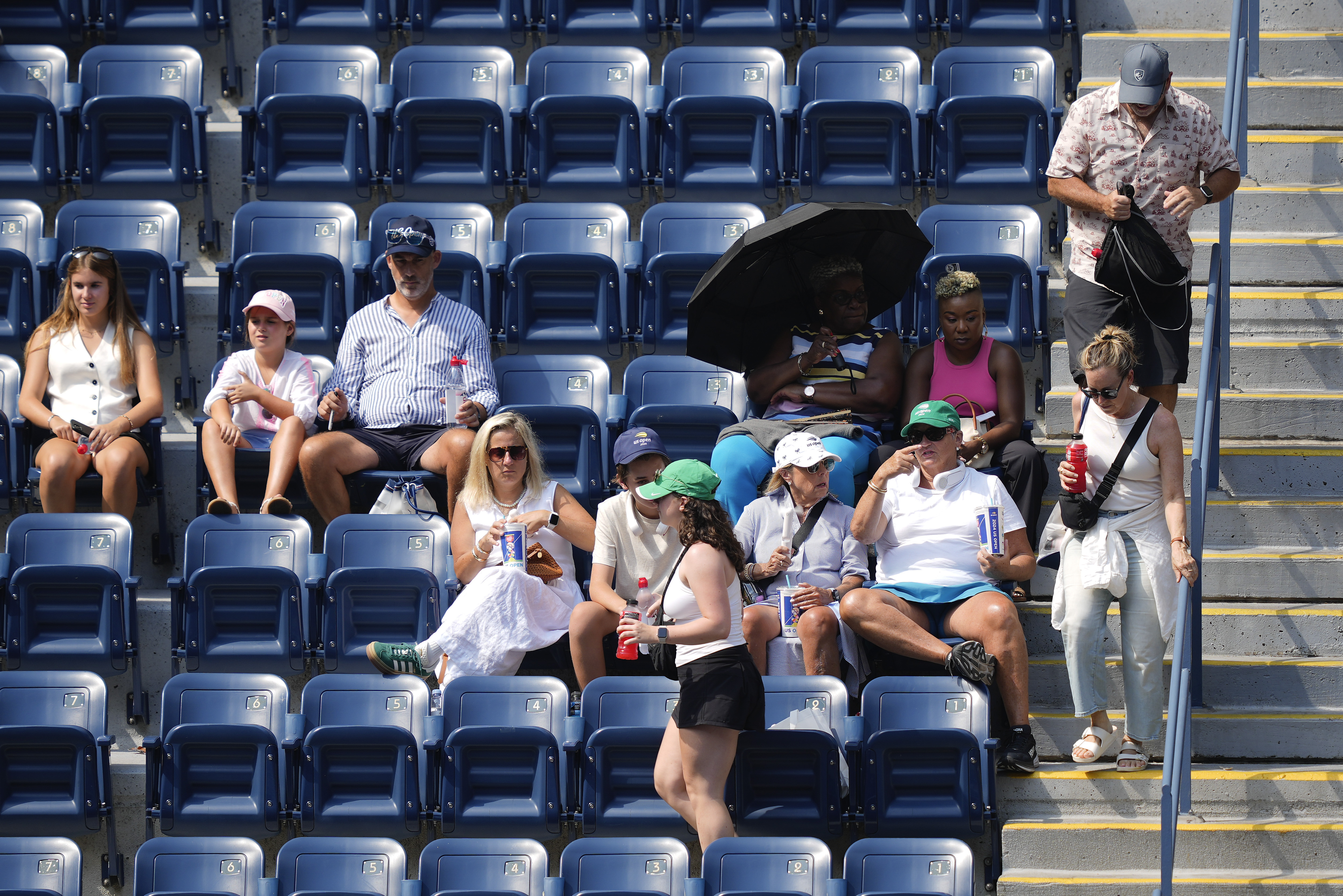 Spectators move to their seats during play between Varvara Gracheva, of France, and Coco Gauff, of the United States, during the first round of the U.S. Open tennis championships, Monday, Aug. 26, 2024, in New York. 